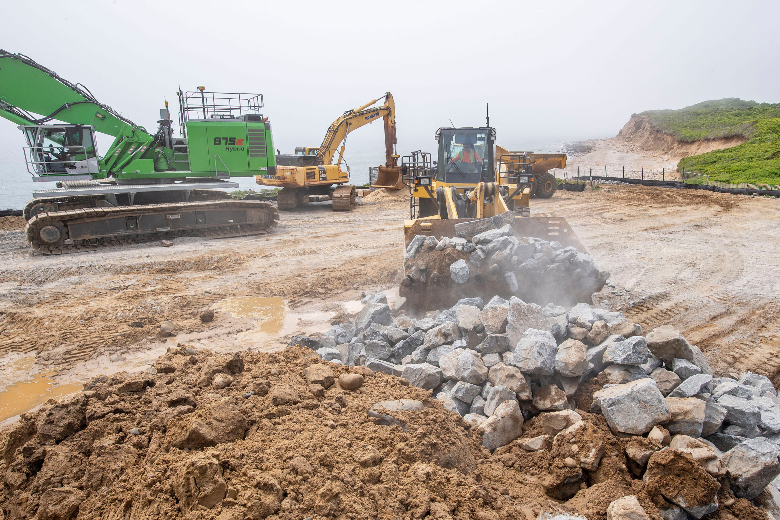 Large stones are transported by a pay loader down to the waterfront as part of the Army Corps of Engineers' Montauk Point Revetment Project on Monday.  MICHAEL HELLER