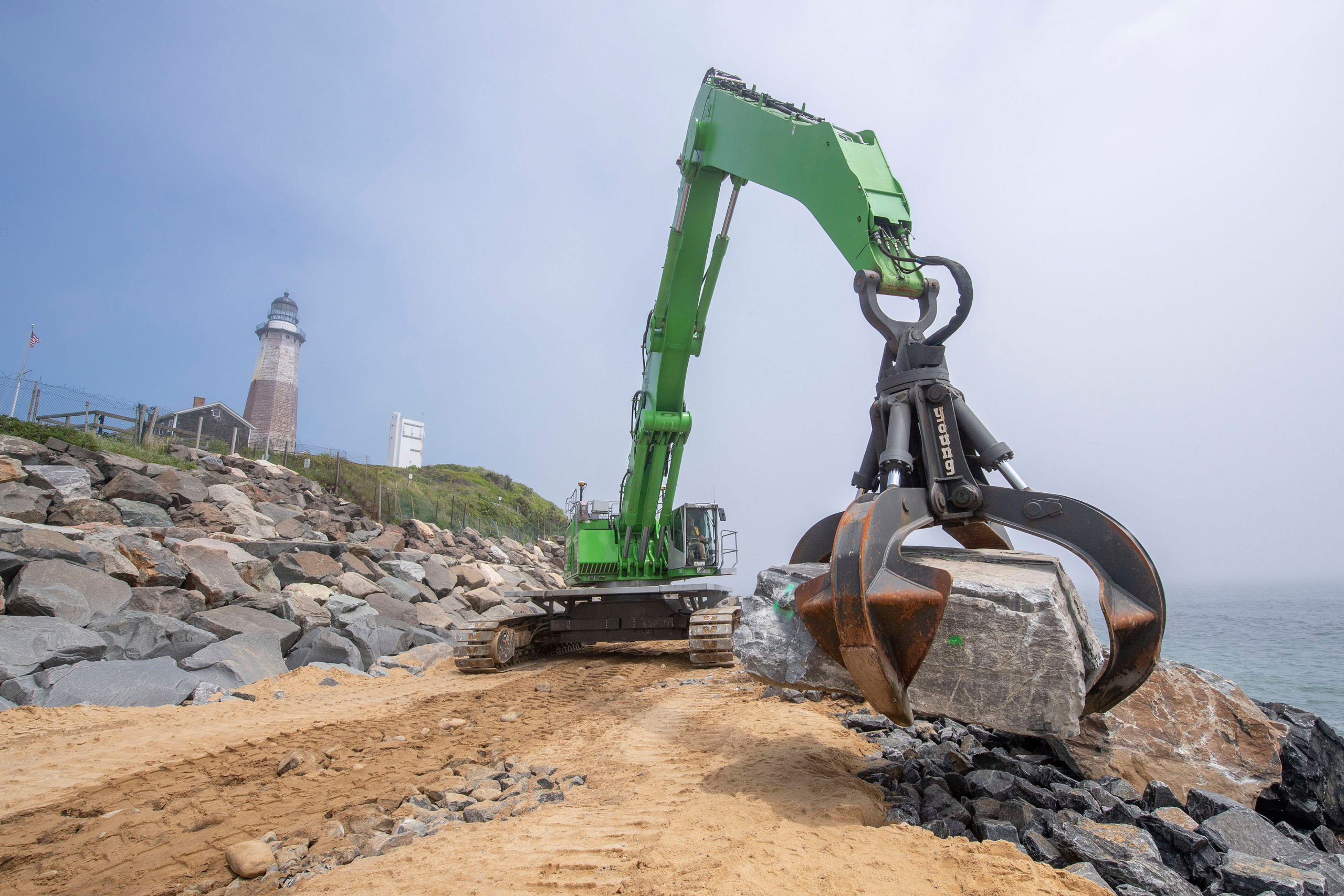 Large boulders - some as large as 15 tons - are moved by a large claw-tipped excavator after being transported from a quarry in upstate New York as part of the Army Corps of Engineers' Montauk Point Revetment Project on Monday.   MICHAEL HELLER