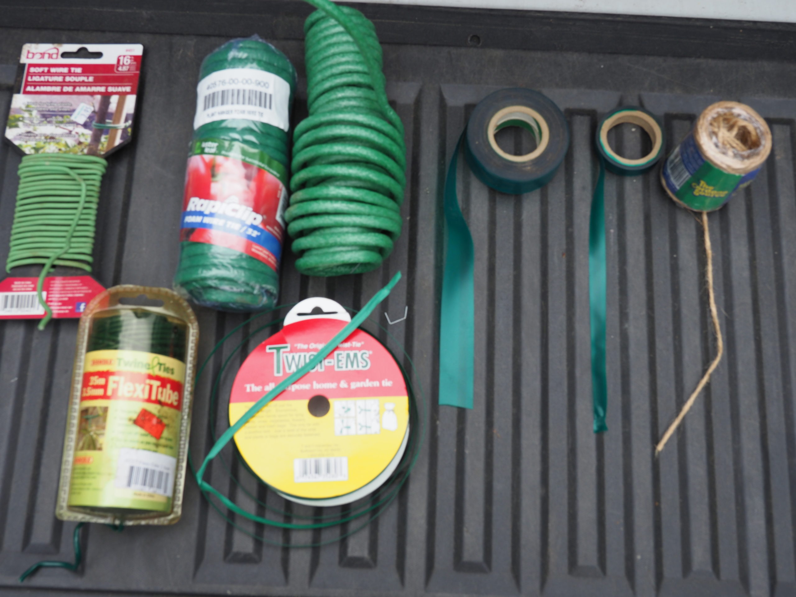 The binding tools of the trade. Three types of covered wire top left and two more on the bottom left. The foam-covered wire in the center is my favorite. One-and-half-inch vinyl stretch tapes center and right top and lastly a roll of natural garden twine. At some point these all come in handy.