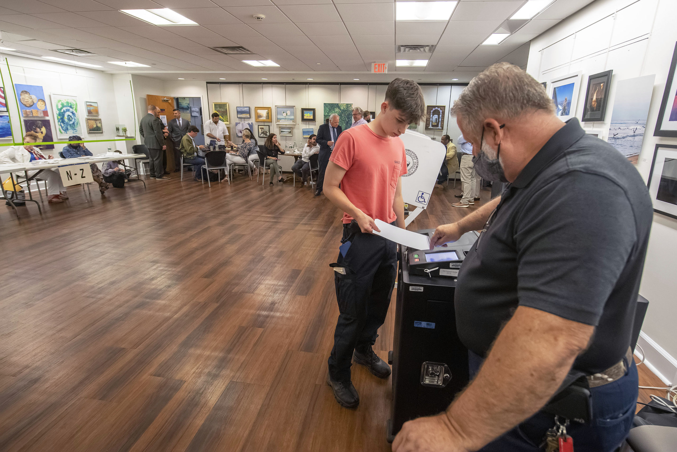 An election official helps a young voter insert his ballot into the voting machine during the 2021 Southampton Village Mayoral election at the Southampton Cultural Center on Friday night. MICHAEL HELLER