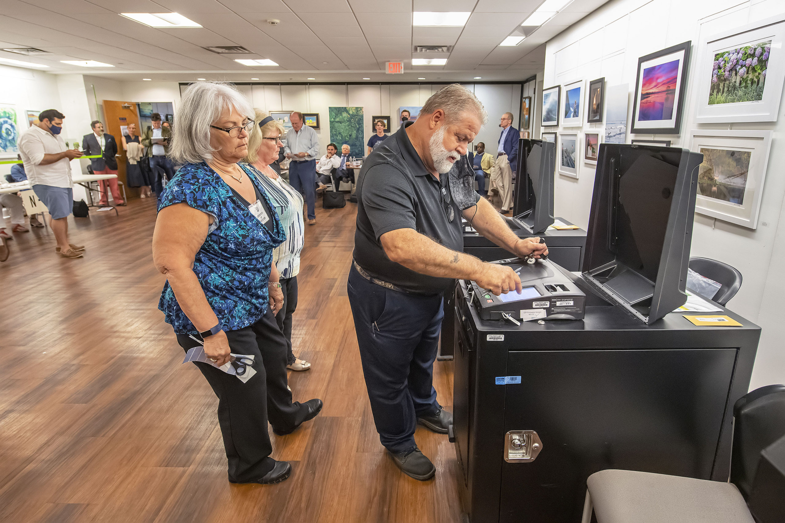 Election Inspectors look on as an election official retrieves the vote count from a voting machine during the 2021 Southampton Village Mayoral election at the Southampton Cultural Center on Friday night. MICHAEL HELLER