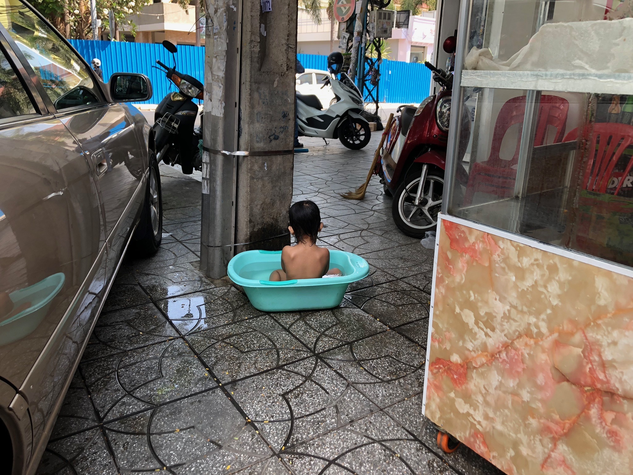 A young boy cooling down in the concrete jungle of Phnom Penn, Cambodia.