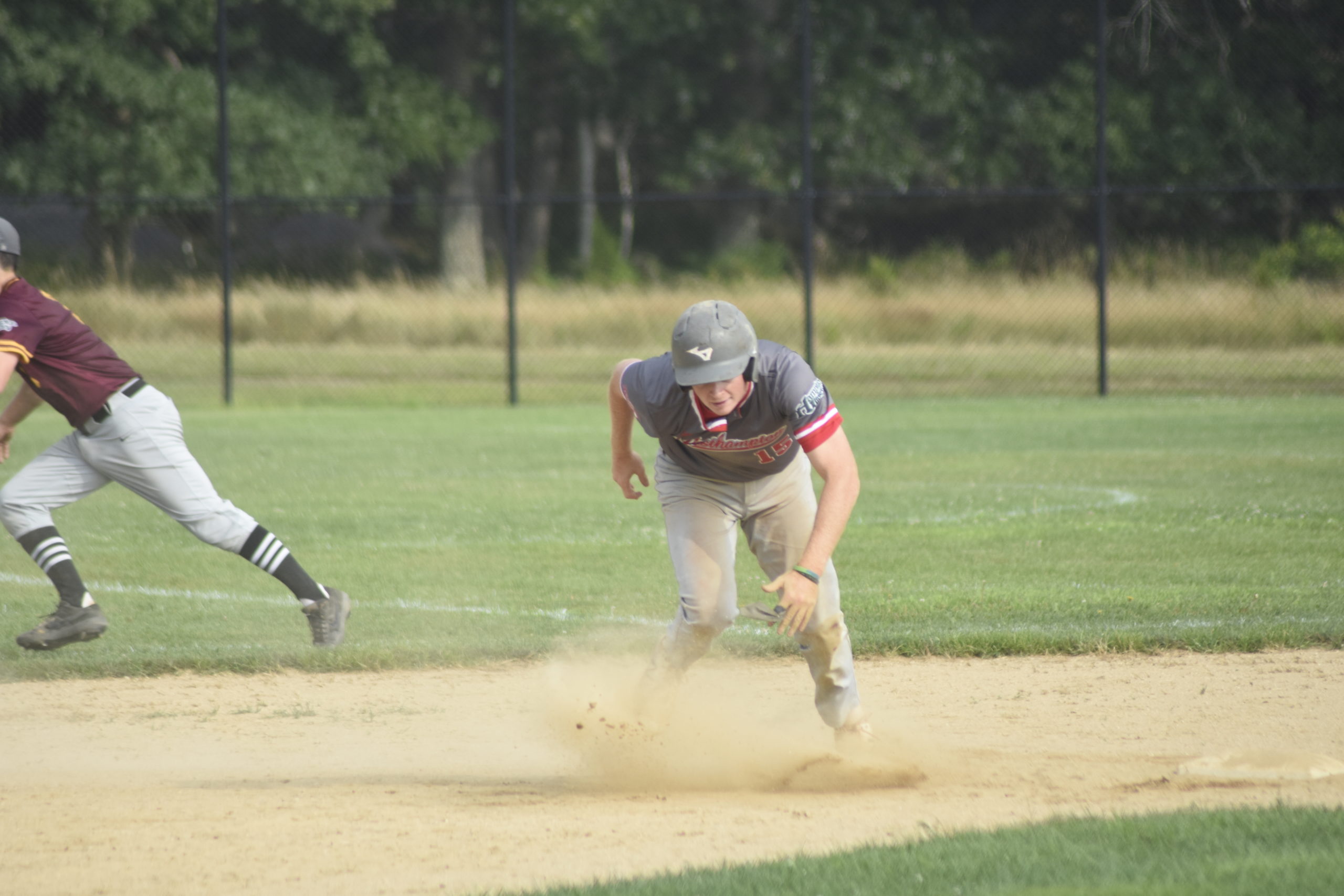 Matt Alifano (Adelphi/Center Moriches) races toward third base after an errant throw goes into the outfield as he stole second base.