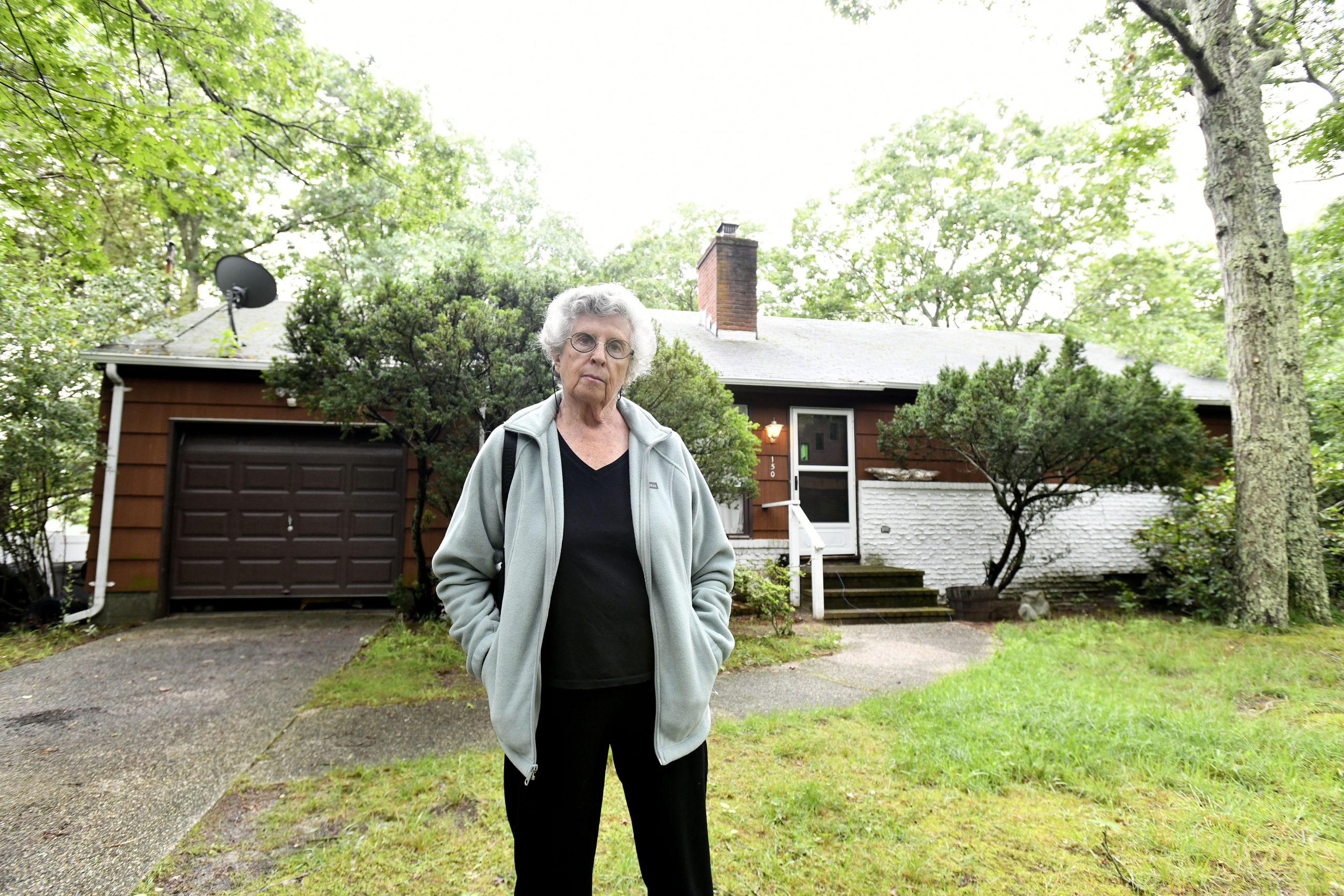 Genya Markon in front of the Hampton Bays home that she owns.     DANA SHAW