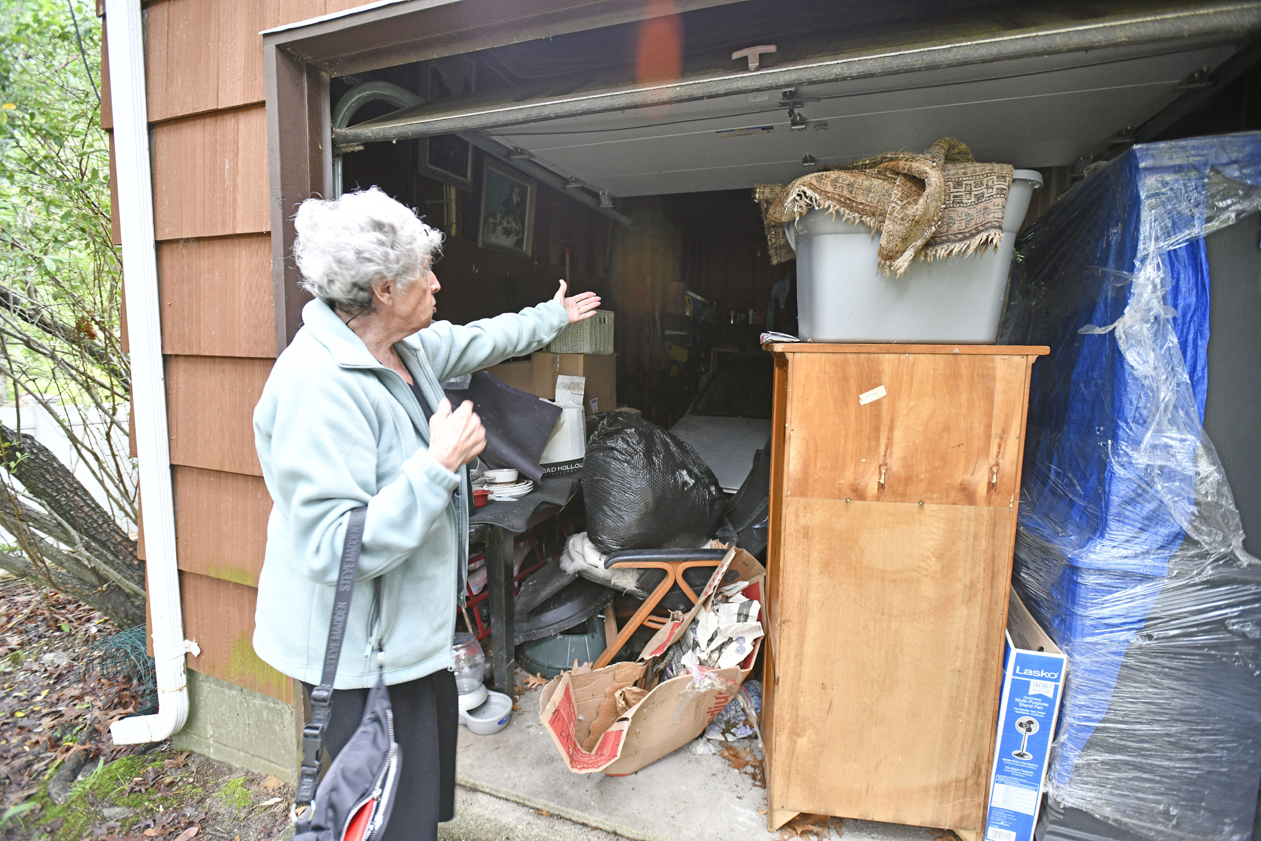 Genya Markon shows some of her damaged items in the garage.            DANA SHAW