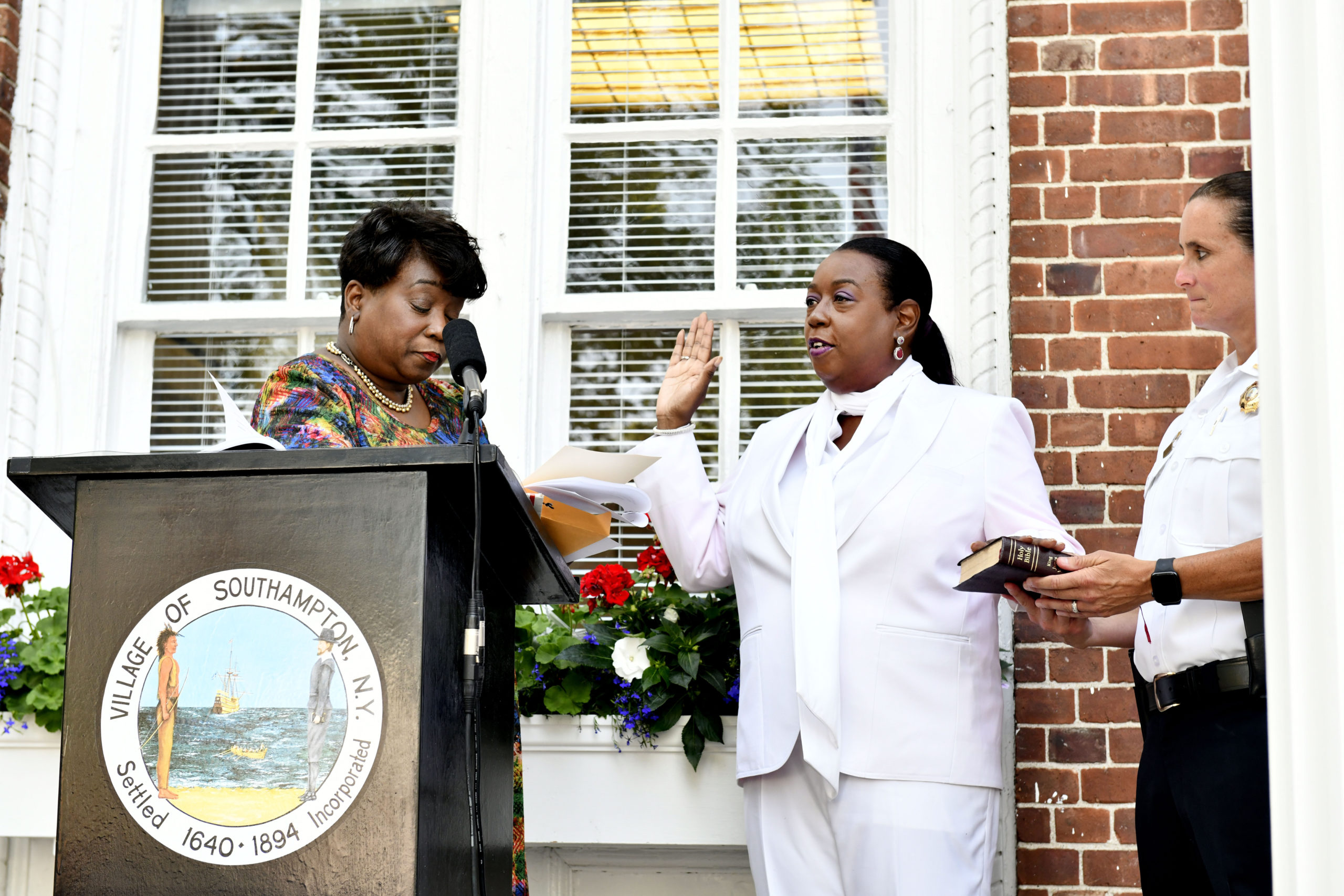 Southampton Village Trustee Robin Brown is sworn in by her cousin Nassau County District Court Judge Andrea Phoenix as Southampton Village Police Lieutenant Suzanne Hurteau witnesses at Village Hall on Tuesday evening.   DANA SHAW