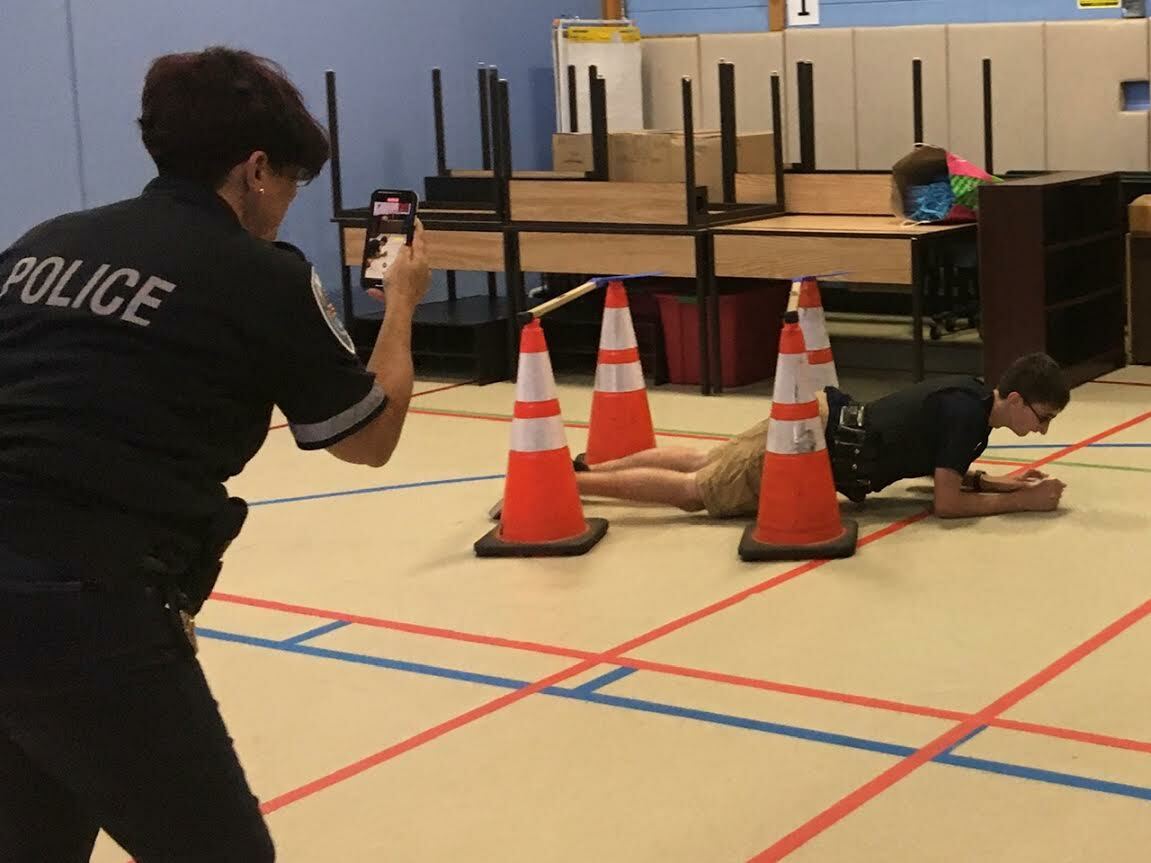 Lt. Sue Ralph films as Ramiro Veliz crawls under an obstacle.