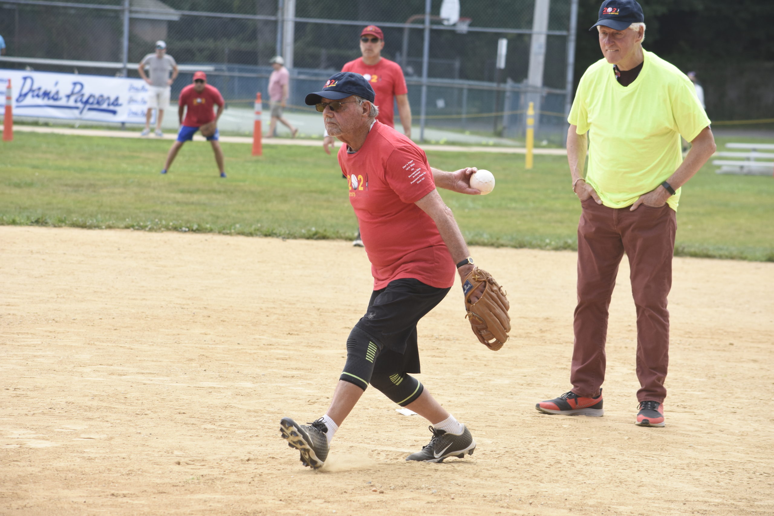 With Bill Clinton calling balls and strikes, artist Walter Bernard throws one of the first pitches of Saturday's game.