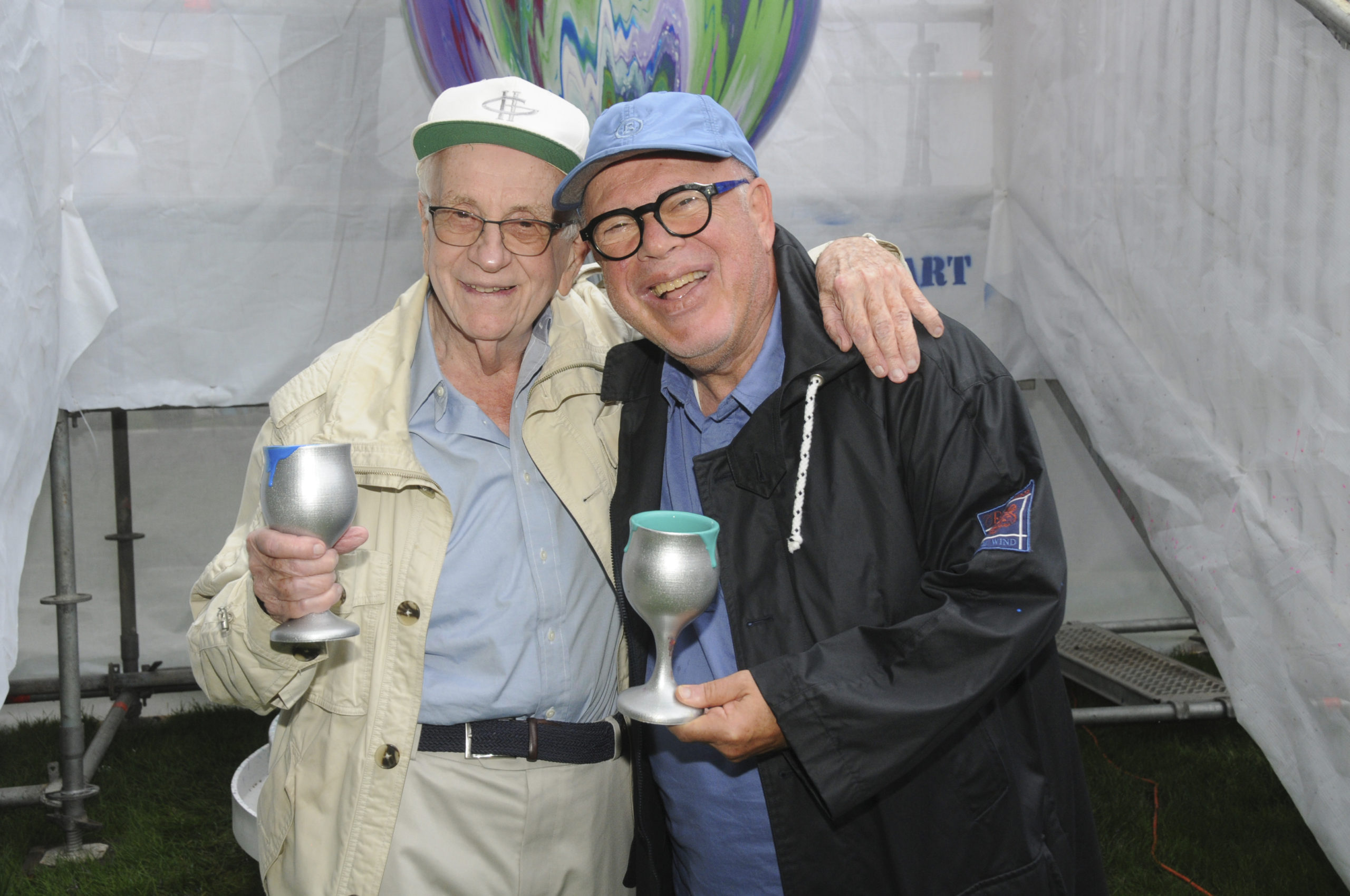 Bernard Goldberg and Norman Stark, two of the founders of the Chabad of the Hamptons, at the 11th Annual Benefit, called “Overflowing Blessings” on August 8. Guests had a chance to brush up on their art skills, as they took turns pouring cups of paint over the eight foot tall Kiddush Cup by Yitzchock Moully, the Pop Art Rabbi.     RICHARD LEWIN
