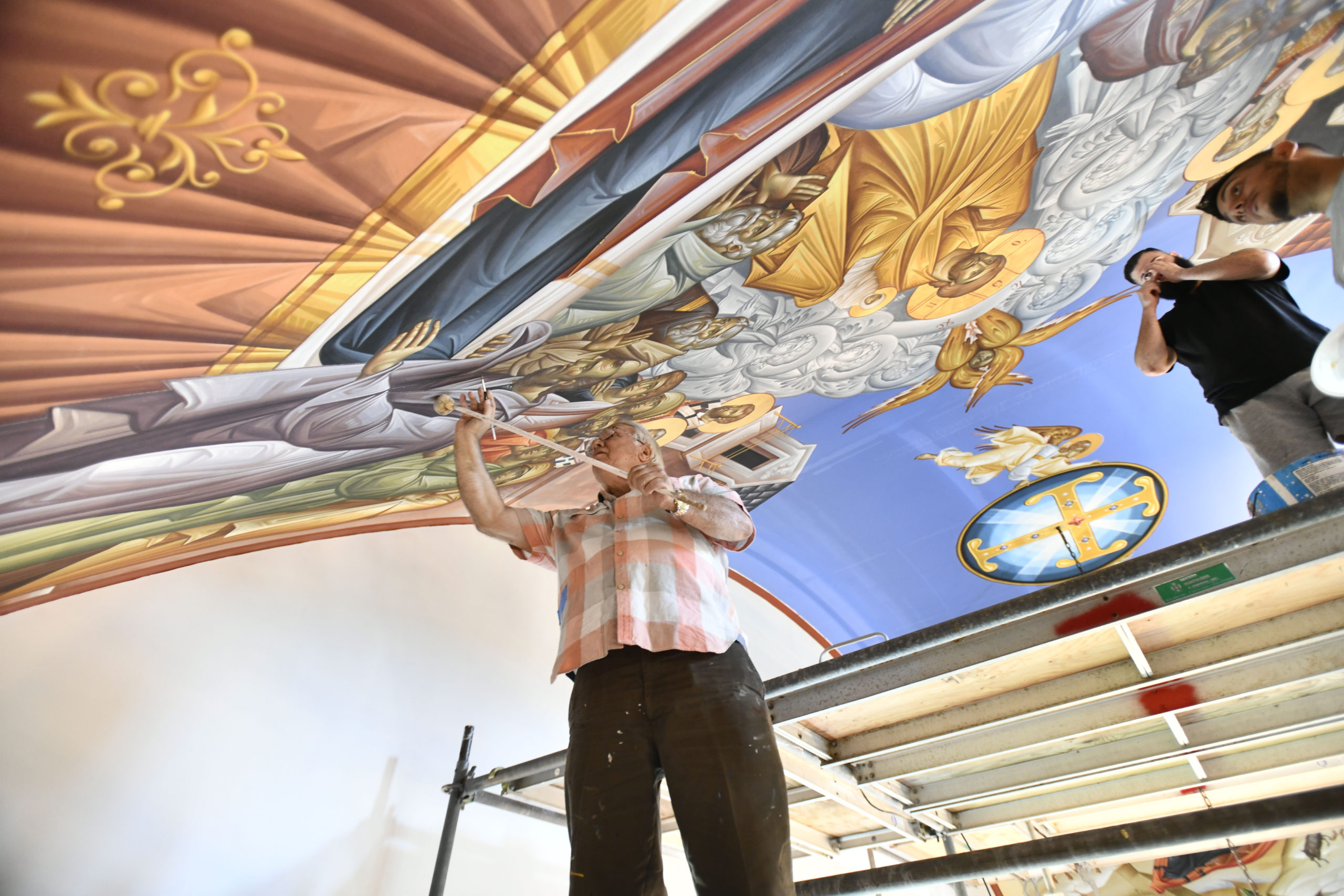 Iconographer George Filippakis works on the ceiling of the Dormition of the Virgin Mary Greek Orthodox Church on Monday. The church will be his last work.  DANA SHAW