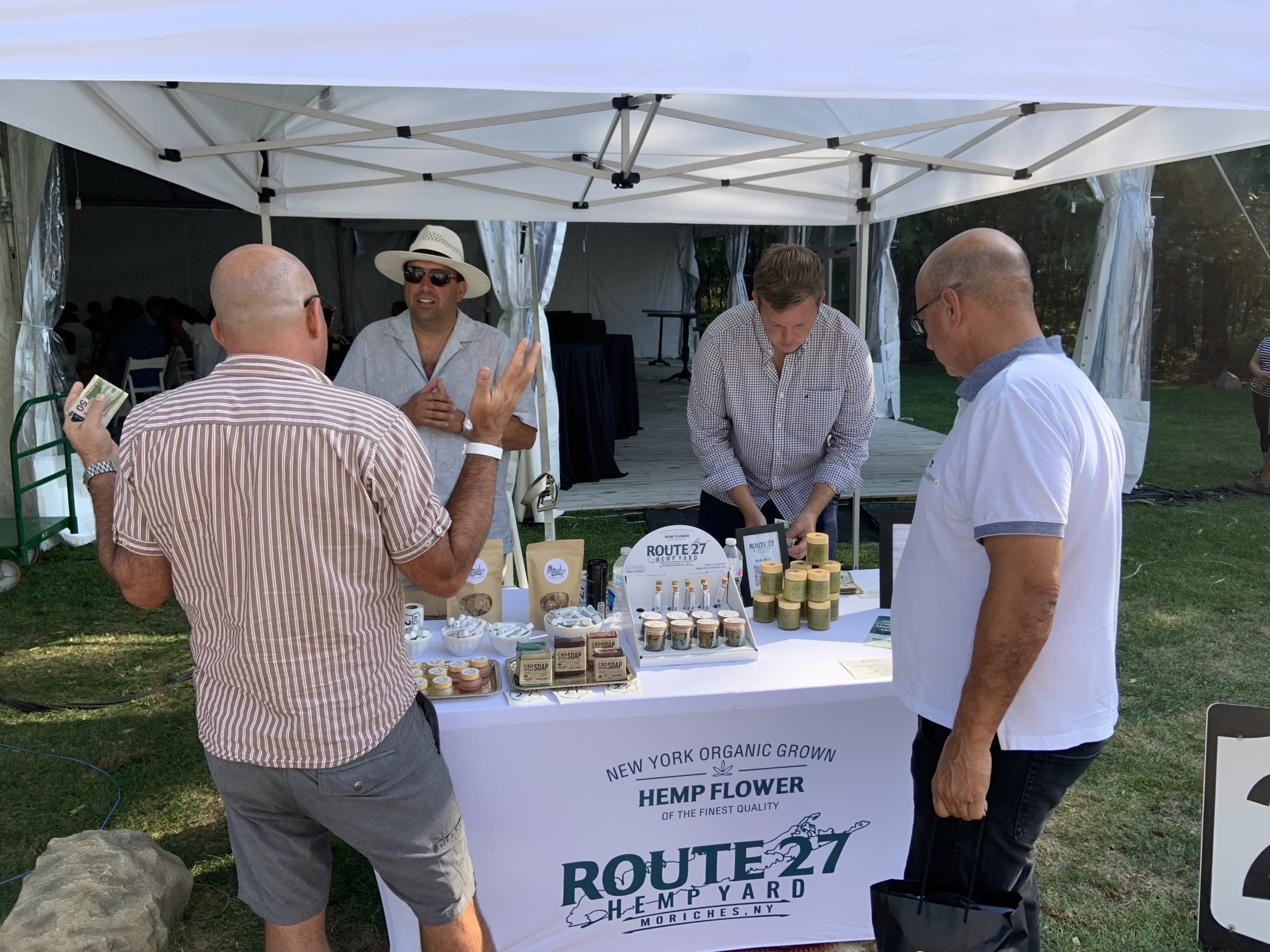 Sean Carroll, left, and Rayan Andoos of Route 27 Hemp Yard in Center Moriches, with two customers at Sunday's Cannabis Expo in East Hampton. STEPHEN J. KOTZ