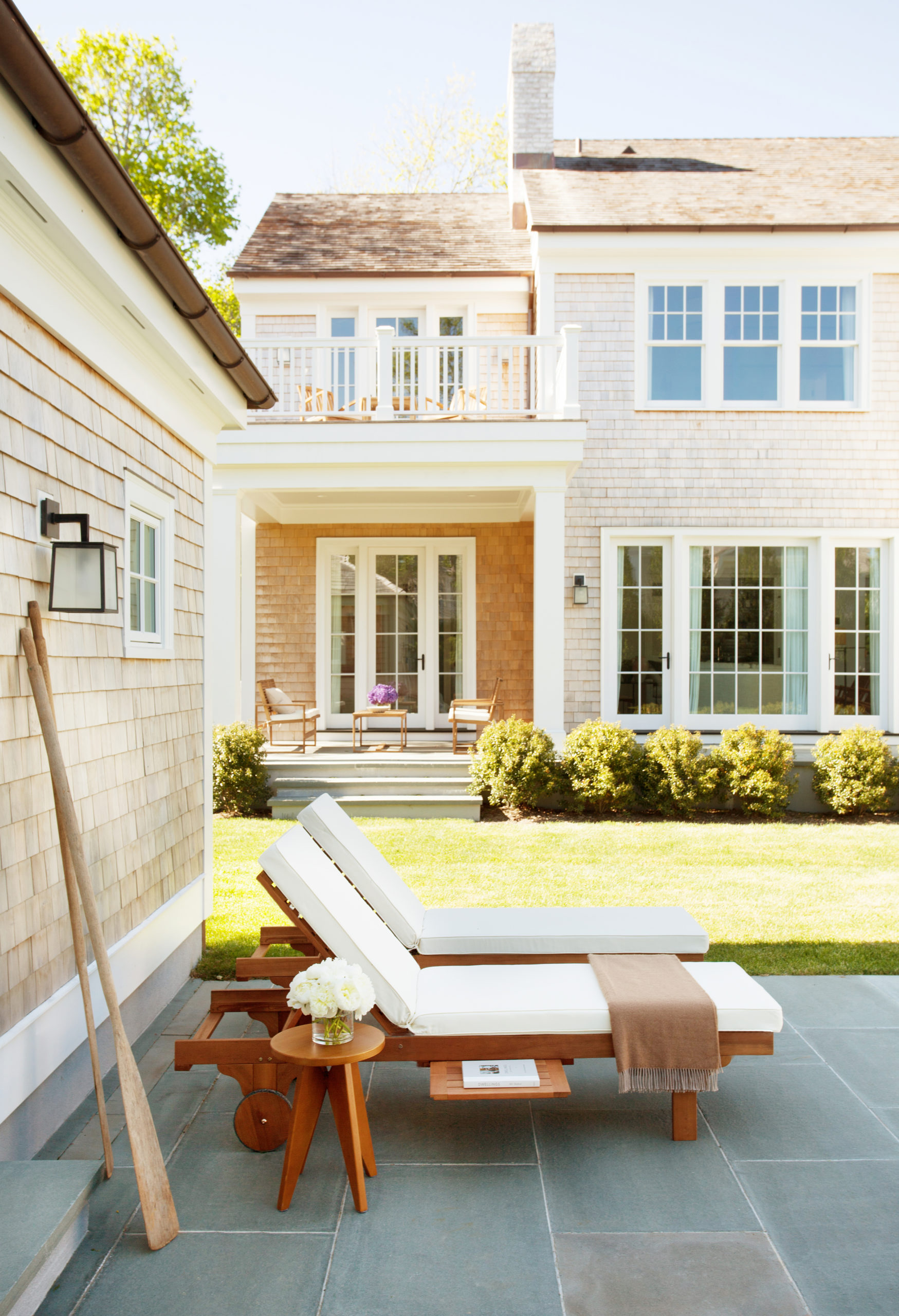 A pair of chaises sit poolside with vintage oars at this Southampton estate. PATRICK CLINE