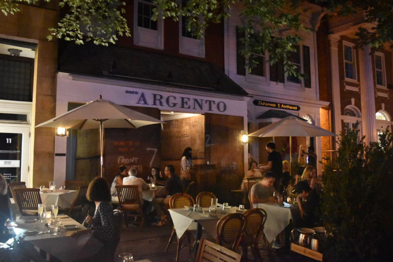 Diners eating outside a boarded up restaurant in Southampton Village Saturday night. ALEC GIUFURTA