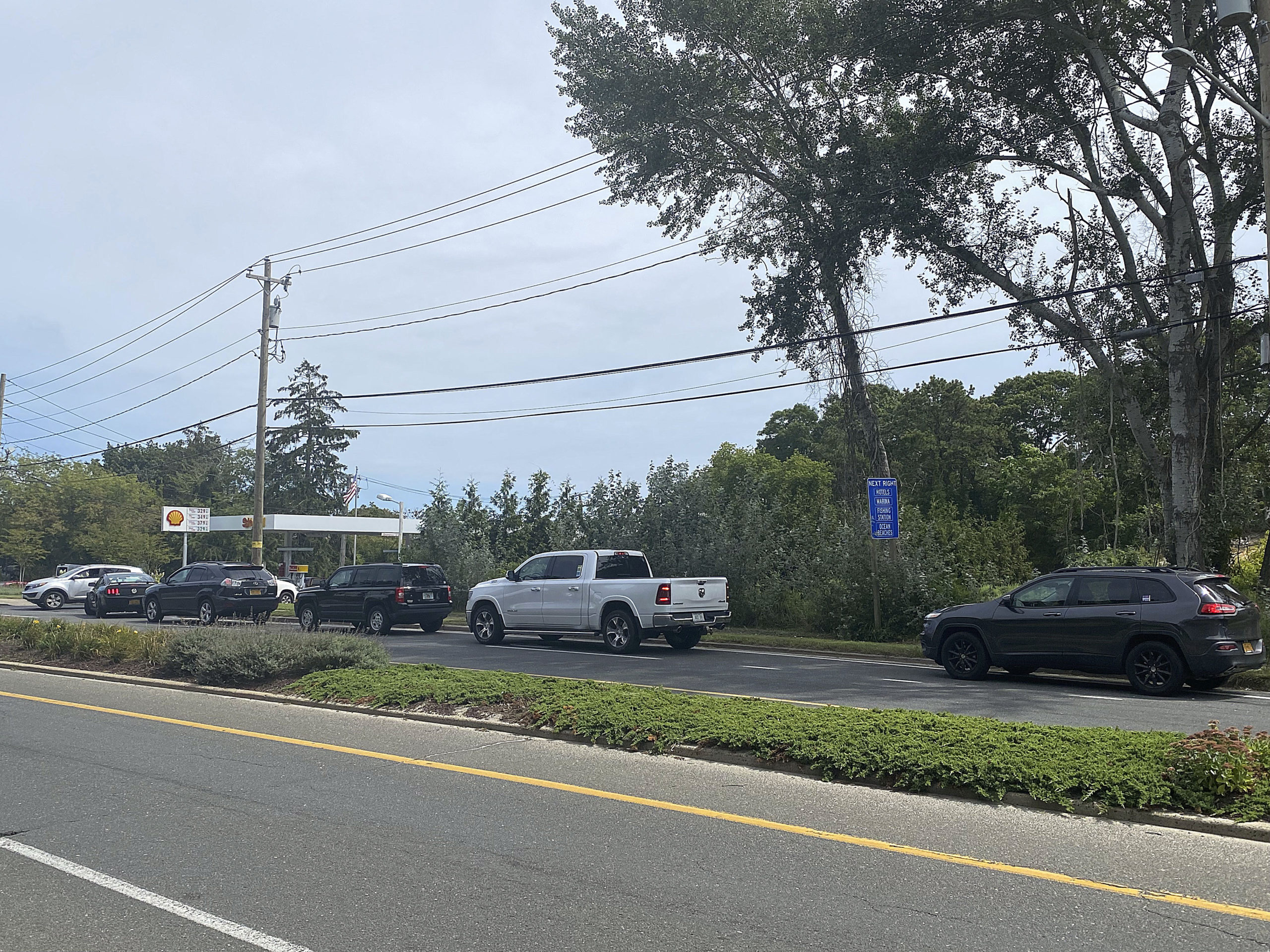 Patrons wait in line to fill up at the Shell station a the corner of Montauk Highway and Canoe Place Road in Hampton Bays on Saturday.  DANA SHAW