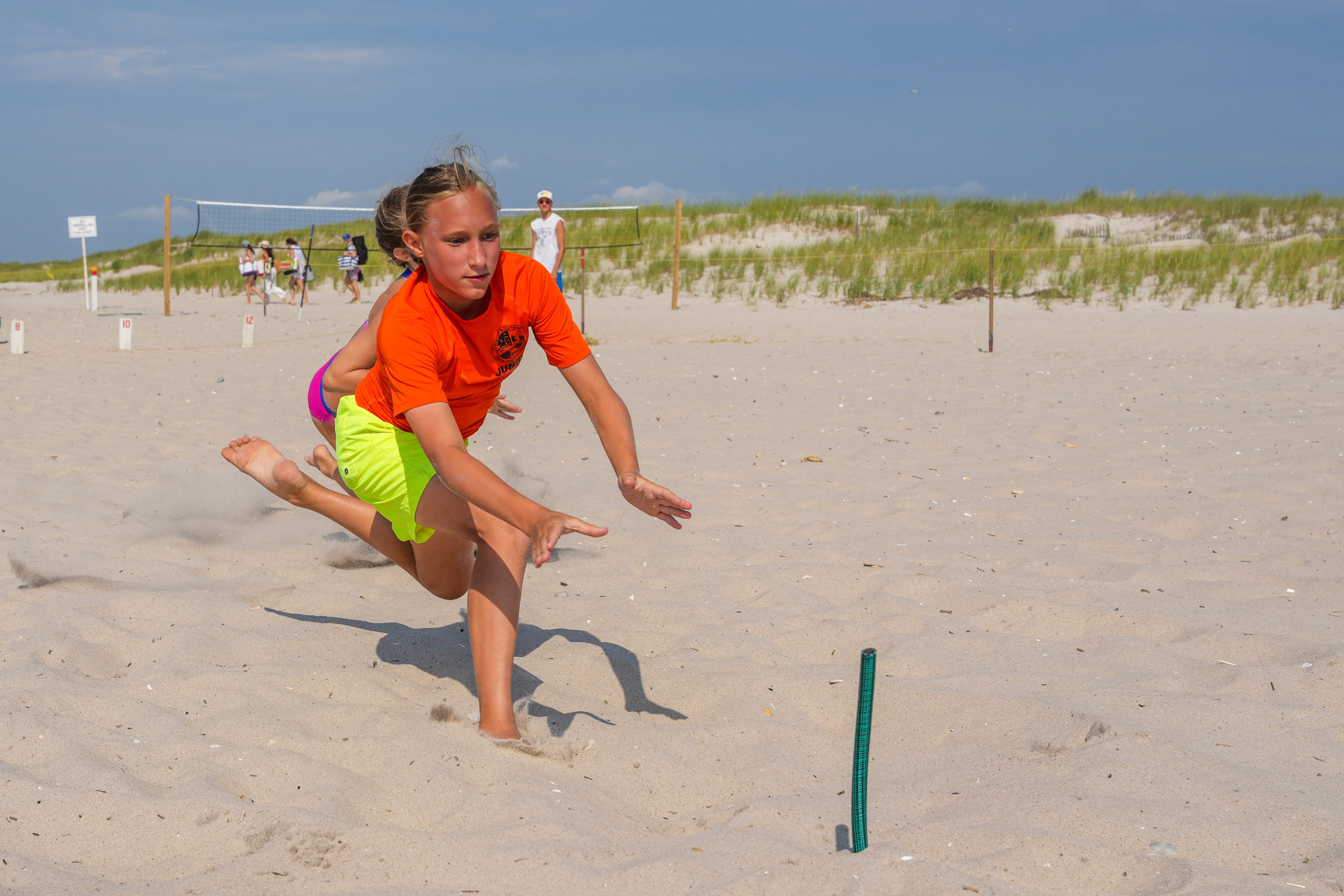 Loie Sommer reaches for a beach flag.