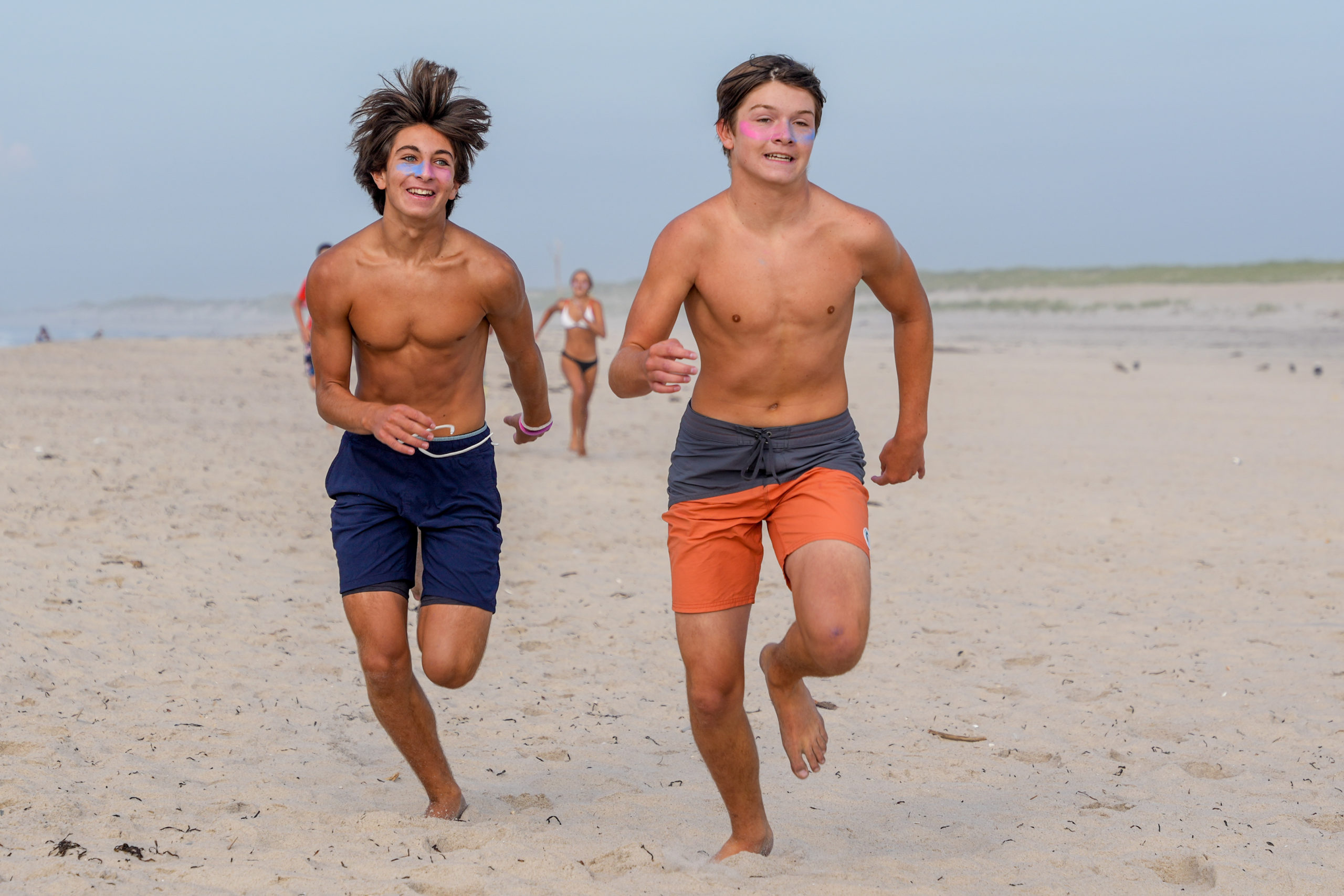 Henry Butler, left, and Aidan Schmitz race down the beach.