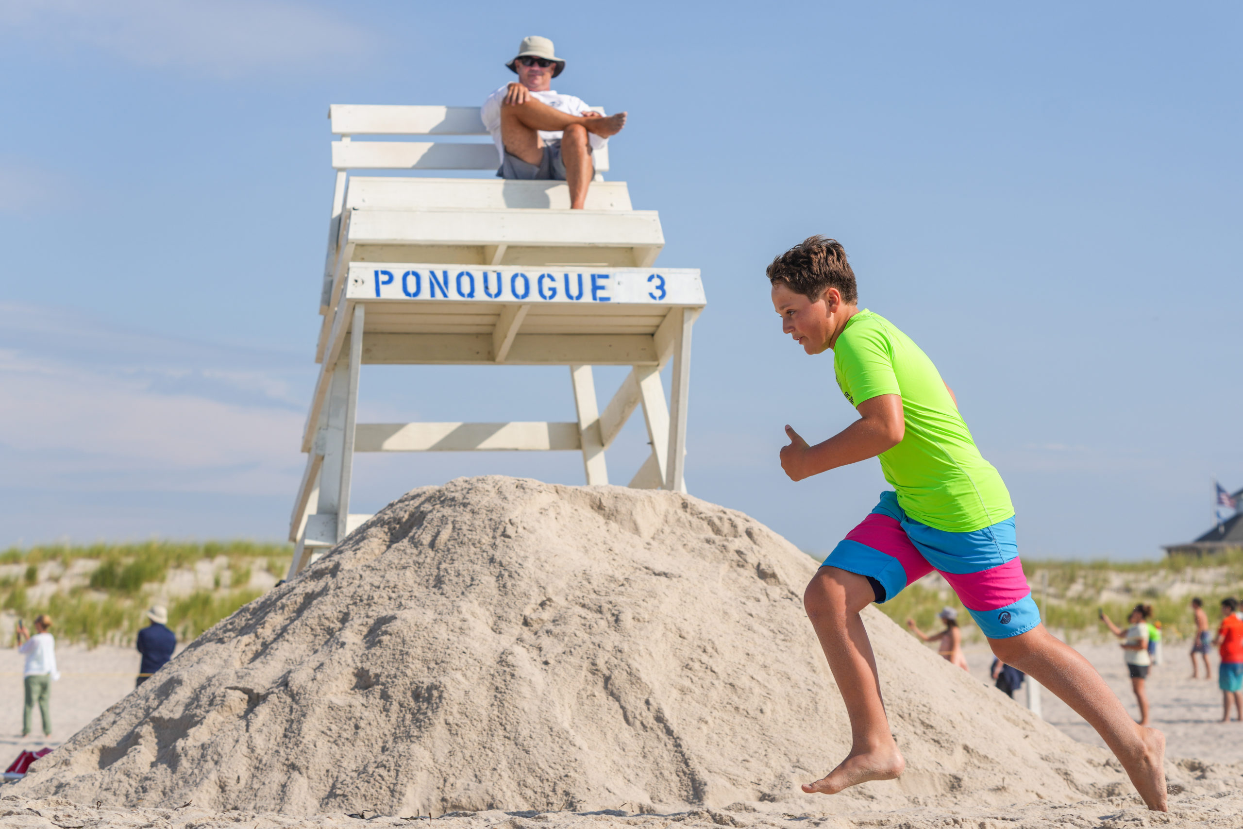 Junior lifeguard Marco Vail runs past Southampton Town head lifeguard Sean Crowley.