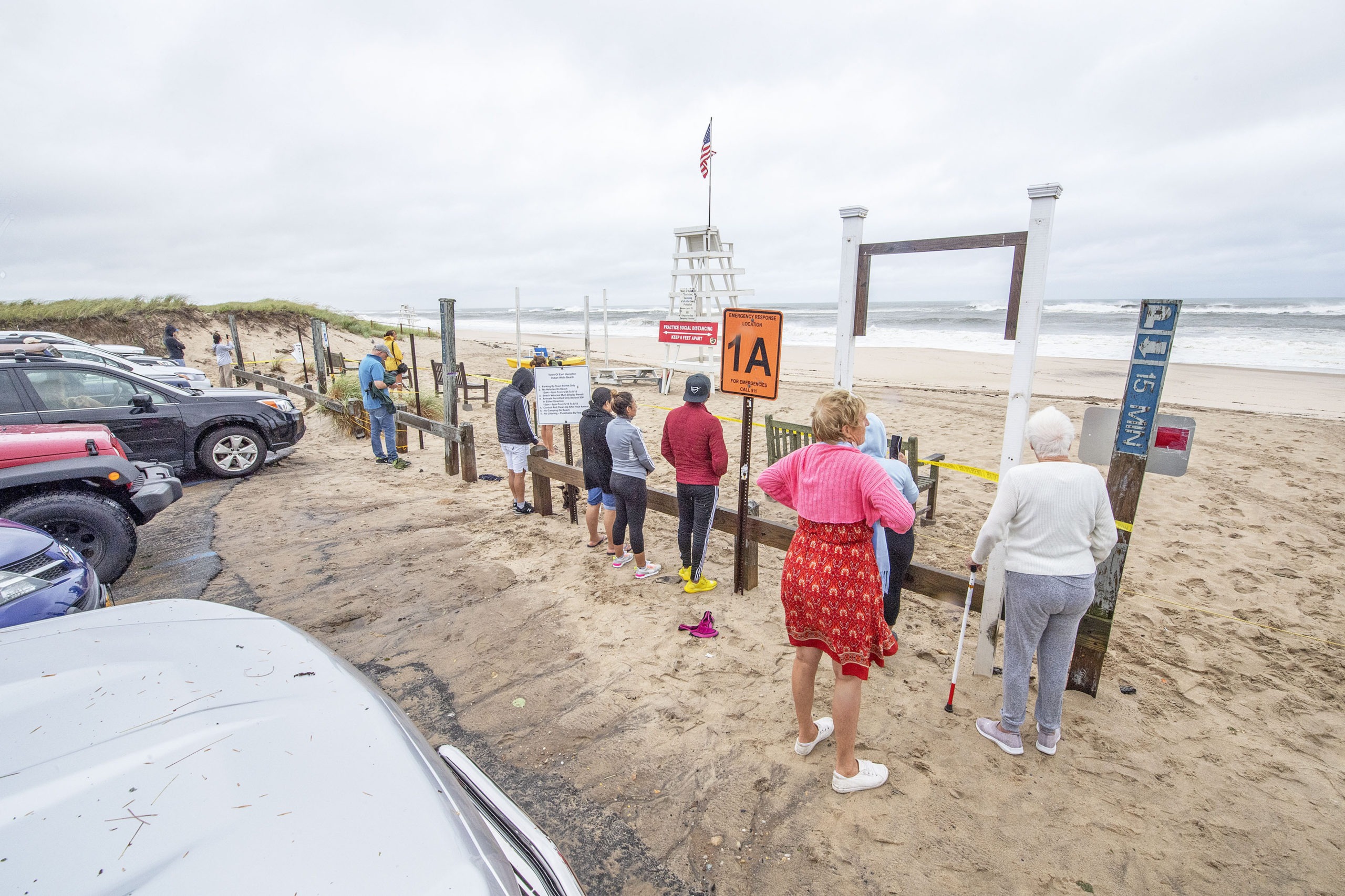 Prohibited from entering onto the beach itself during the storm, curious onlookers gather at the beachhead at Indian Wells Beach in Amagansett to watch the surf during Tropical Storm Henri on Sunday.    MICHAEL HELLER