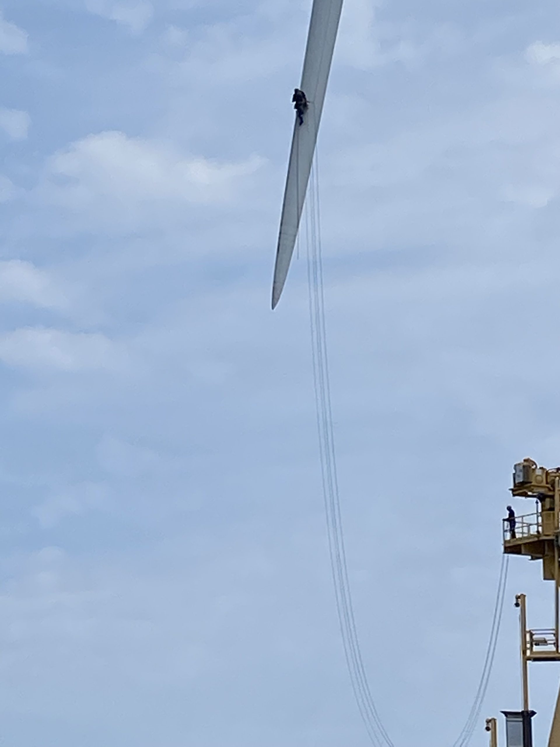 A maintenance worker on the tip of one of the 240-foot wind turbine blades at the Block Island Wind Farm. An Orsted spokesperson said that the blade maintenance is routine and not part of the structural issues that have forced the wind farm to shut down operations this summer.
