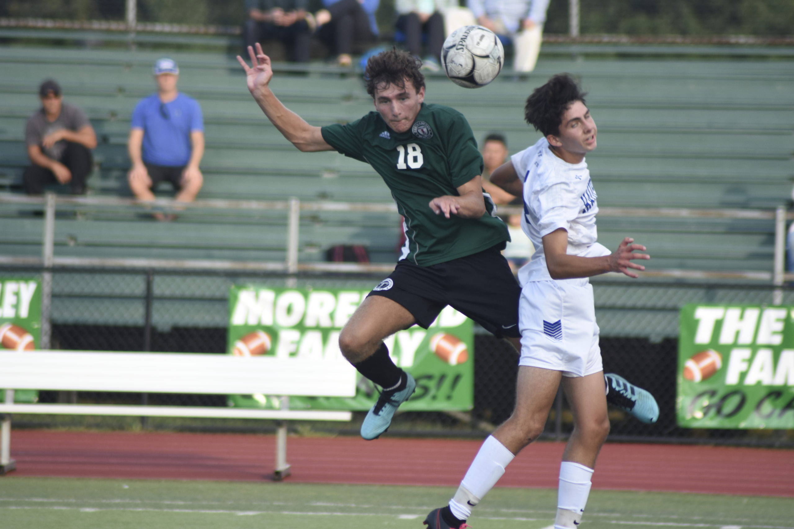 Westhampton Beach senior Michael Griffin and a Hauppauge player collide mid-air going up for a free ball.
