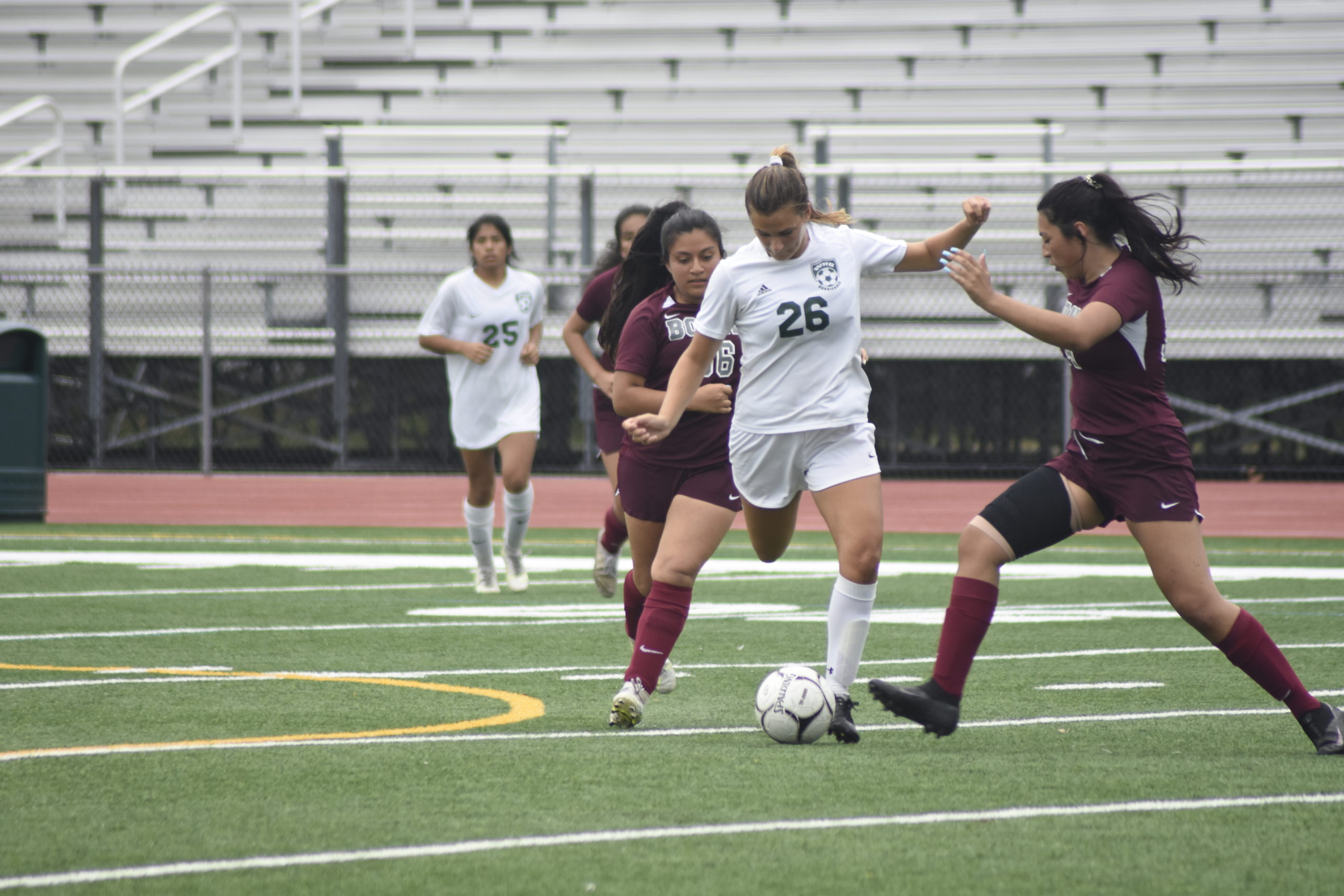 Sensing pressure from a pair of East Hampton players, Westhampton Beach junior Isabella Blanco clears the ball.