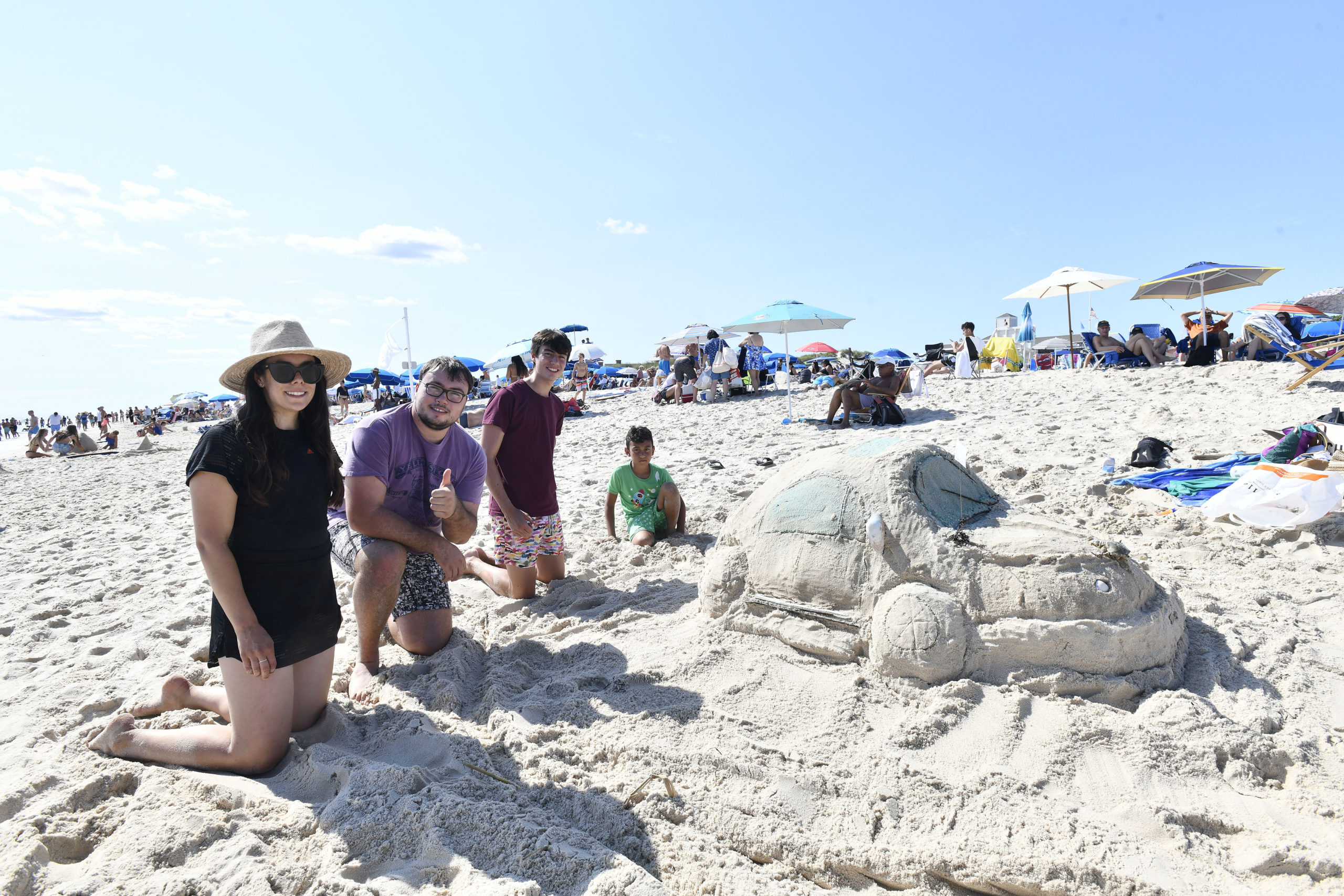 Gloria Dios, Ted and Nate Loquet and Sati Dios with their Volkswagen Bug at the Coopers Beach Annual Sandcastle Contest on Saturday afternoon.  DANA SHAW
