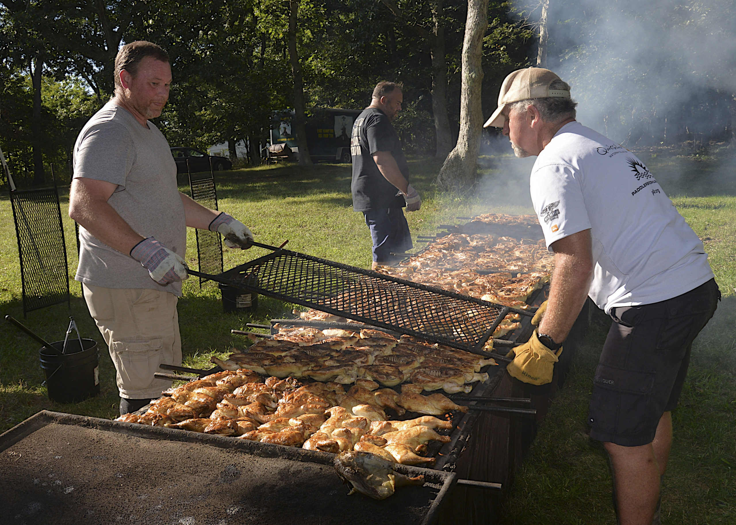Steve Lynch Jr and Bob Pucci prepare the birds at the East Hampton Lions Club chicken barbeque at the Amagansett American Legion on Saturday.  KYRIL BROMLEY