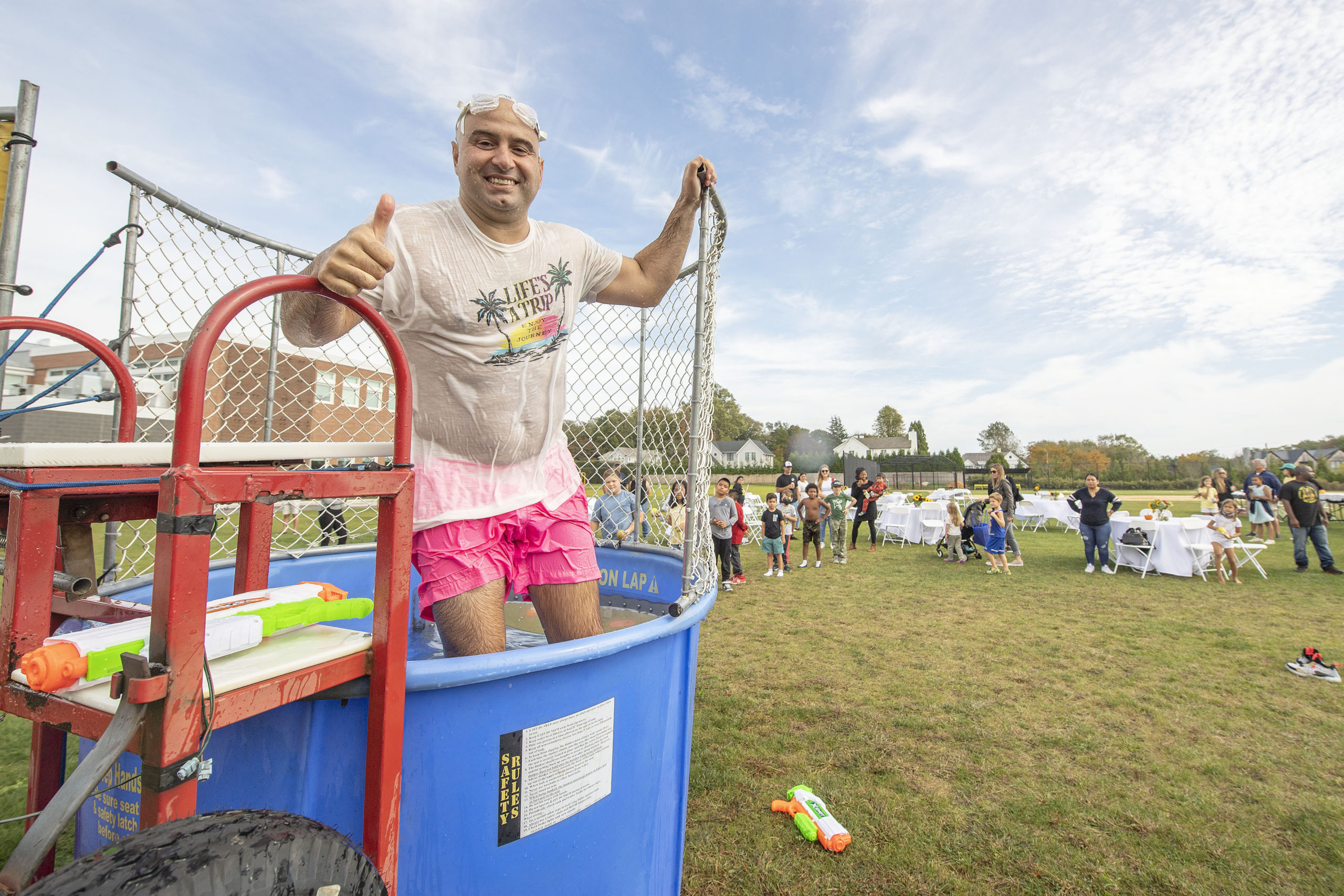Bridgehampton School Athletic Director Michael DeRosa gives a thumbs-up after being dunked by a student during the first annual Bridgehampton Community Day that was held behind the Bridgehampton School on Saturday.     MICHAEL HELLER