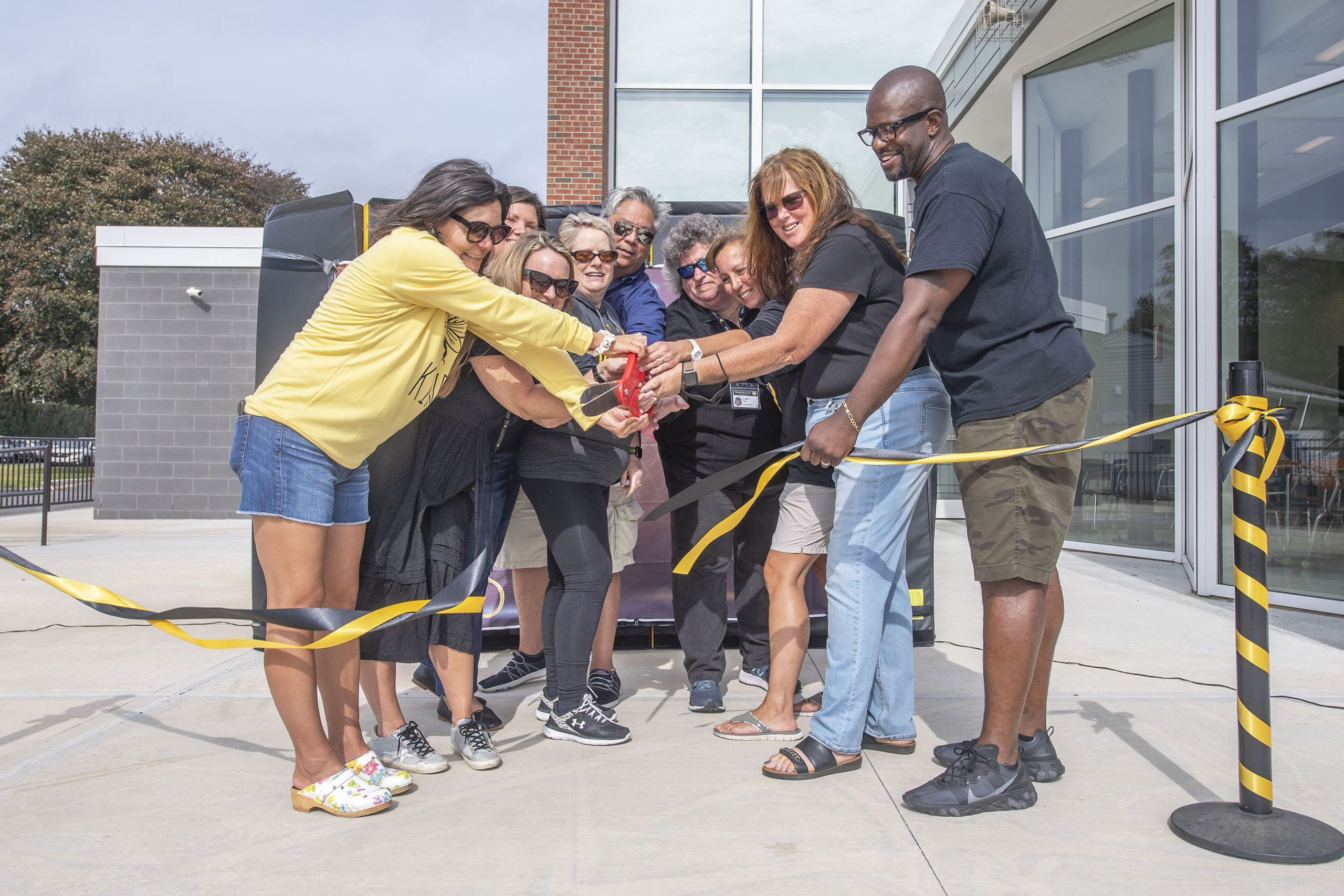 Bridgehampton School Board President Ron White, at far right, is joined by Superintendent Dr. Mary Kelly and other board members as they cut the ribbon to officially open the new addition to the Bridgehampton School during the first annual Bridgehampton Community Day that was held behind the Bridgehampton School on Saturday.   MICHAEL HELLER