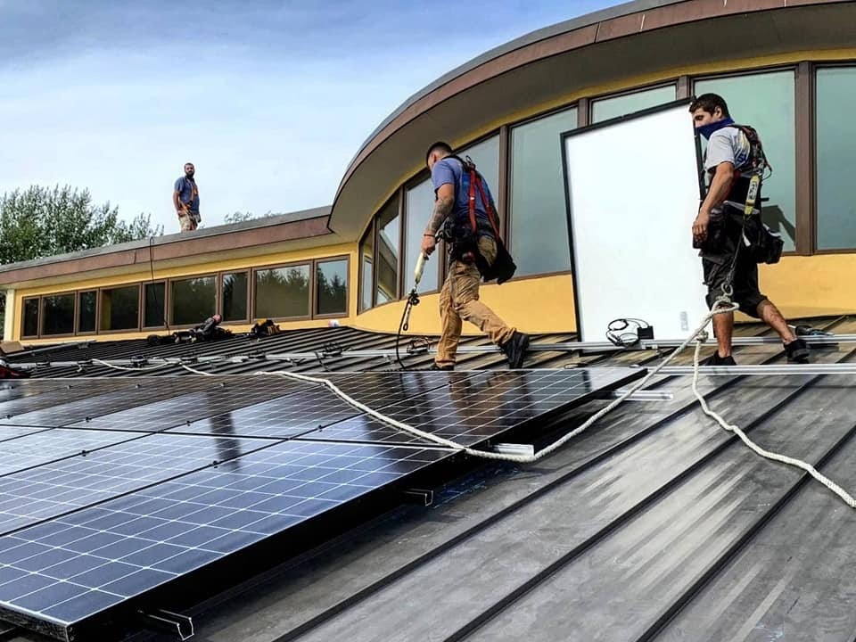 Workers install new solar panels on the roof of the Wuneechanunk Shinnecock Preschool on Monday. LONG ISLAND PROGRESSIVE COALITION PHOTO