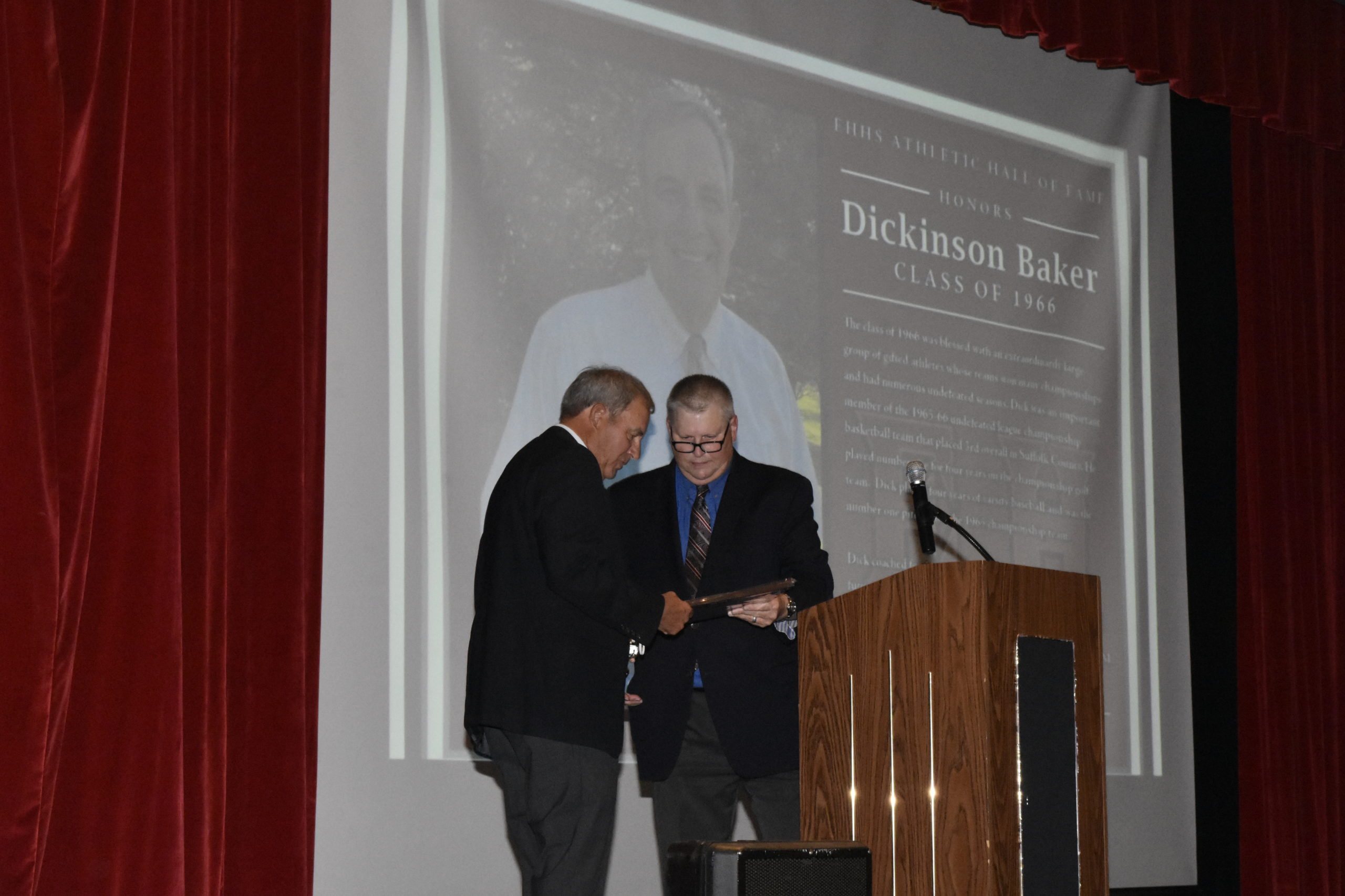 Richard Schneider hands Dickinson Baker his Hall Of Fame plaque.