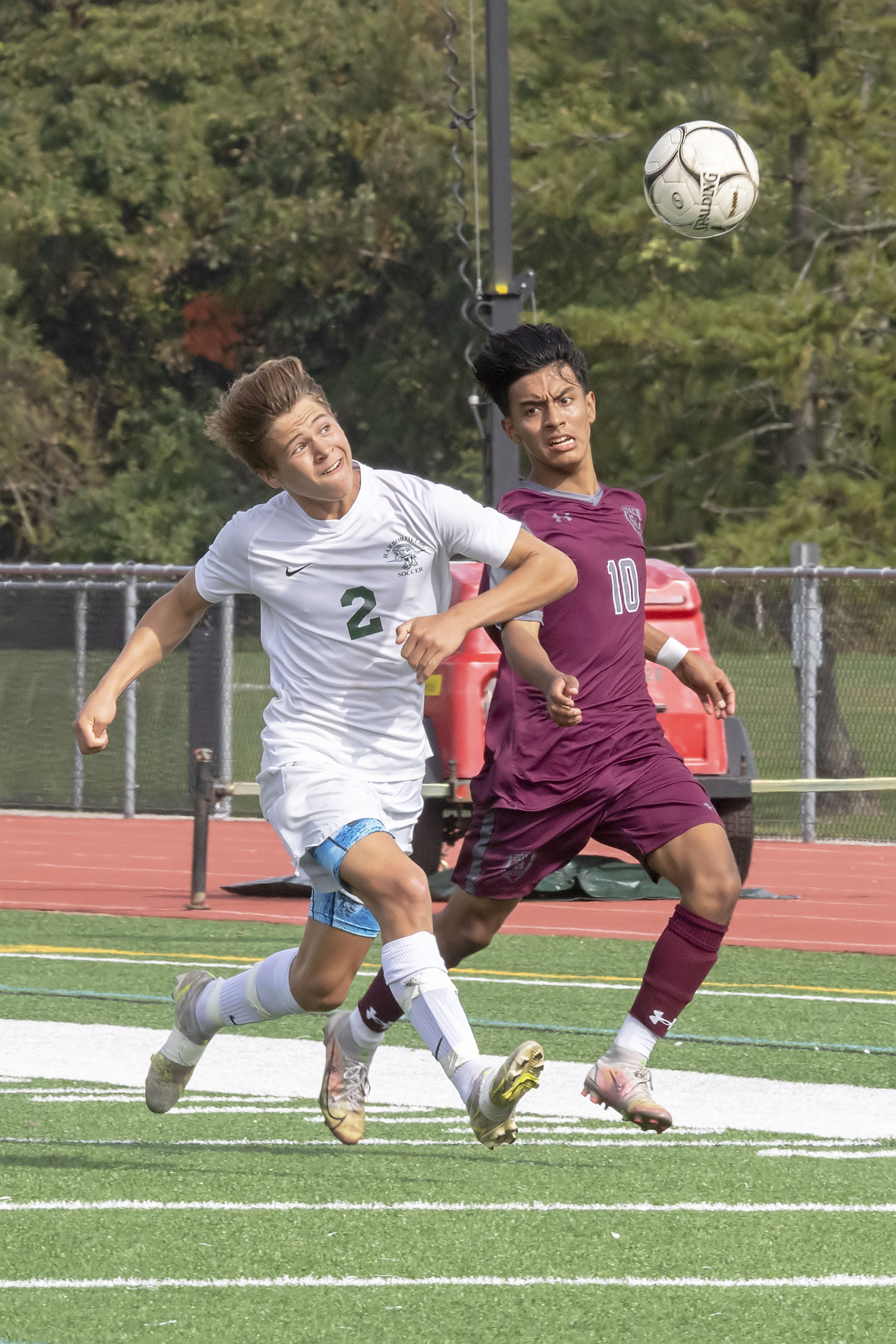 East Hampton's Eric Armijos goes to head the ball with a Harborfields player defending.