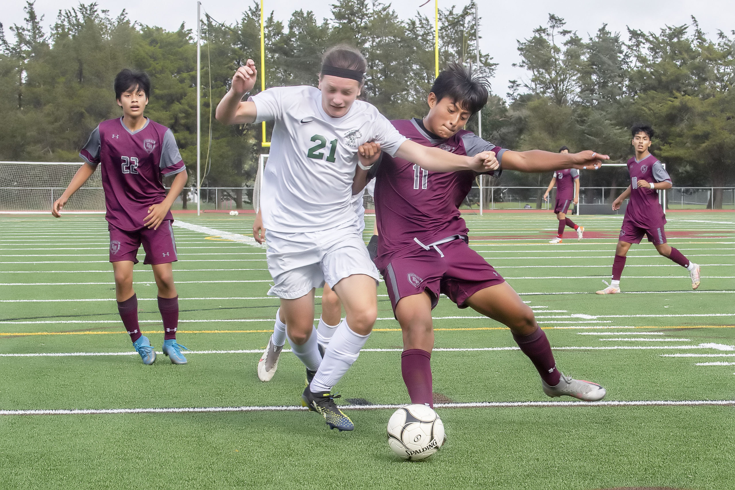 East Hampton's John Quizhpe and a Harborfields player battle for ball control.