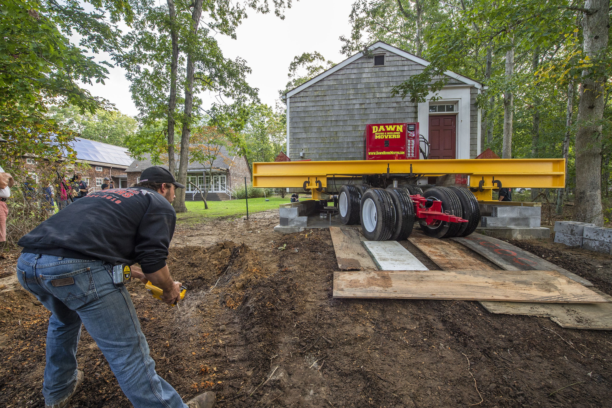 Stanley Kazel III uses a wireless remote control as the old North Haven Schoolhouse was moved by Dawn House Movers from its location at the corner of Payne Avenue and Ferry Road to its new home adjacent to North Haven Village Hall on Tuesday.     MICHAEL HELLER
