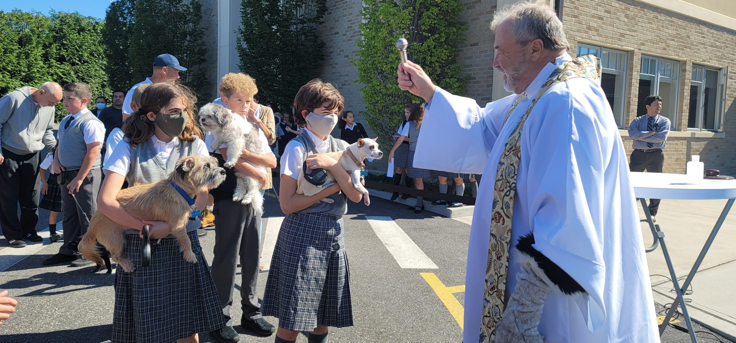 Our Lady of the Hamptons students Emma and LucyTillotson and Brian Spellman bring their pets to to be blessed during the annual Blessing of the Animals.