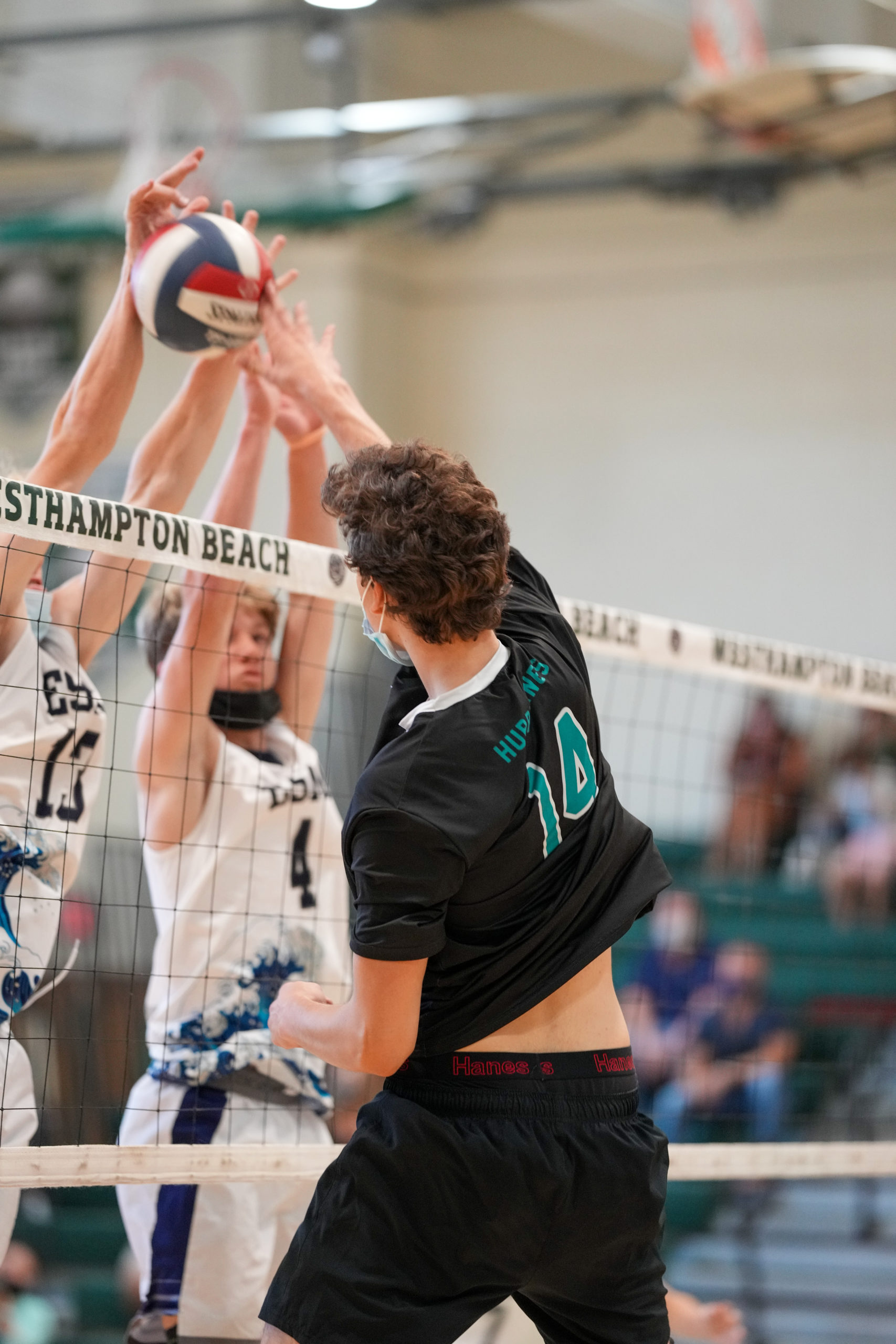 Westhampton Beach senior outside hitter Daniel Haber spikes the ball over Eastport-South Manor blockers.