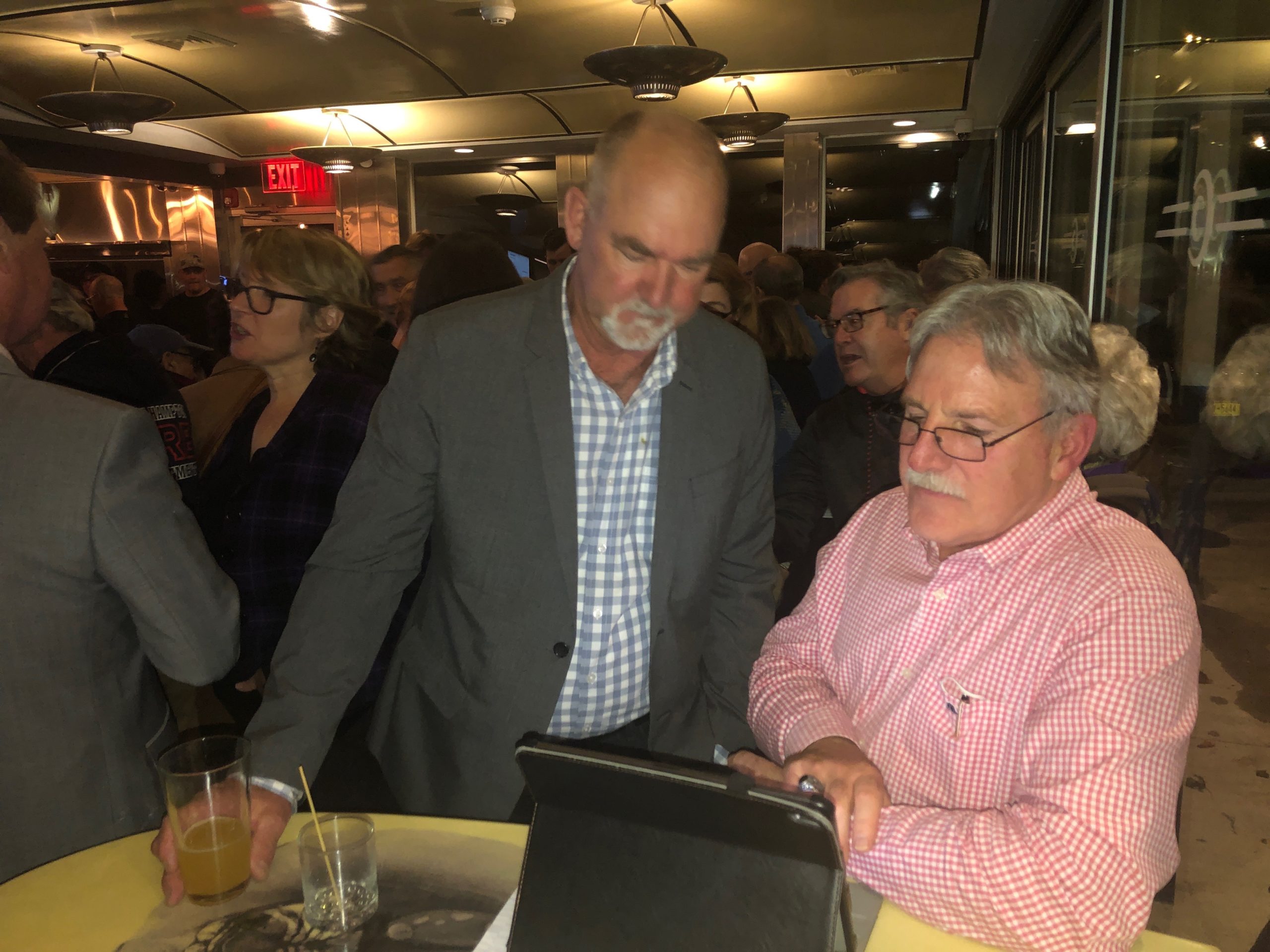 Supervisor Peter Van Scoyoc and Chris Kelly watch election returns on Tuesday night at Democratic headquarters. MICHAEL HELLER