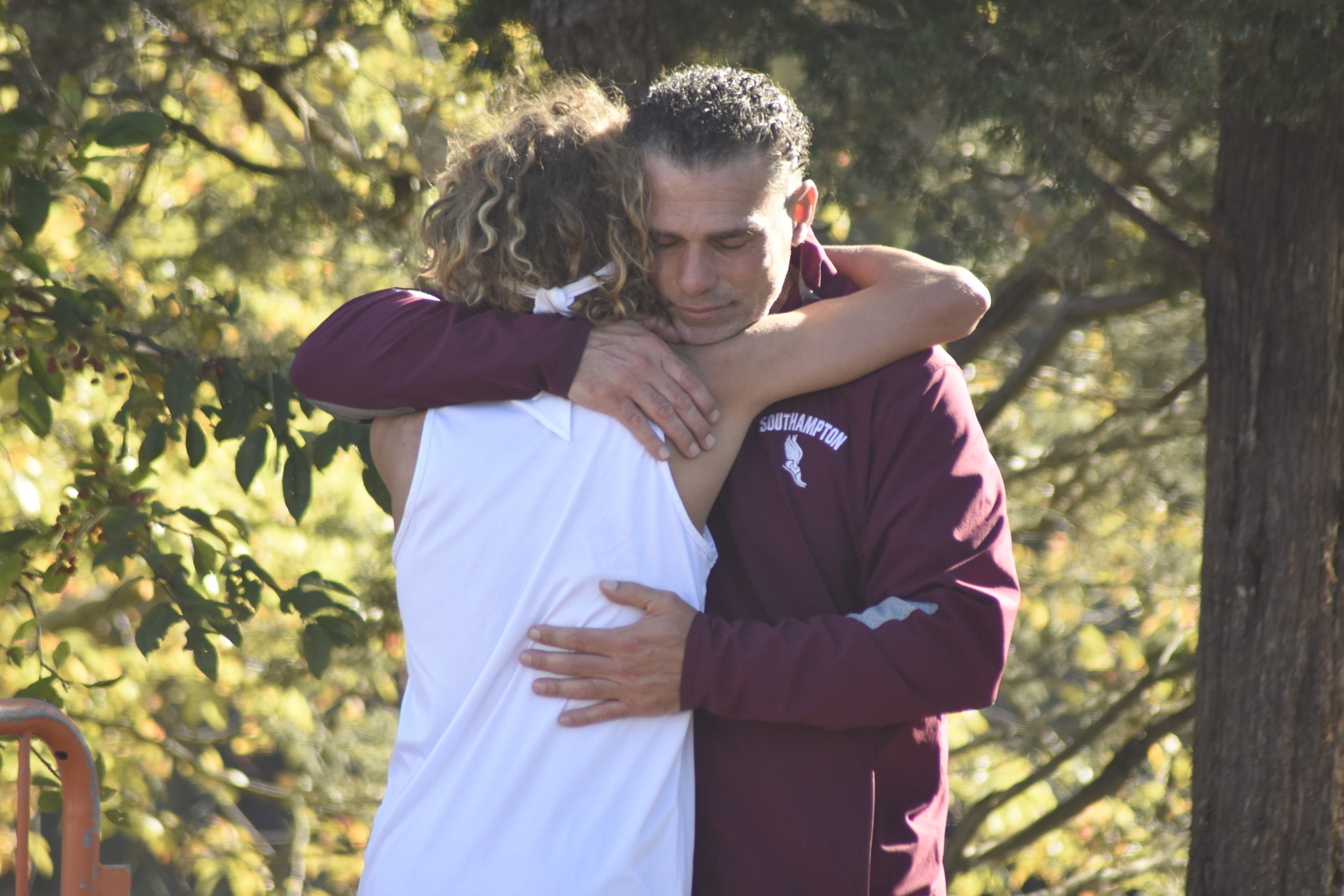 Saintino Arnold and his father and head coach Eddie Arnold share a moment after he finished his final race of his cross country tenure.