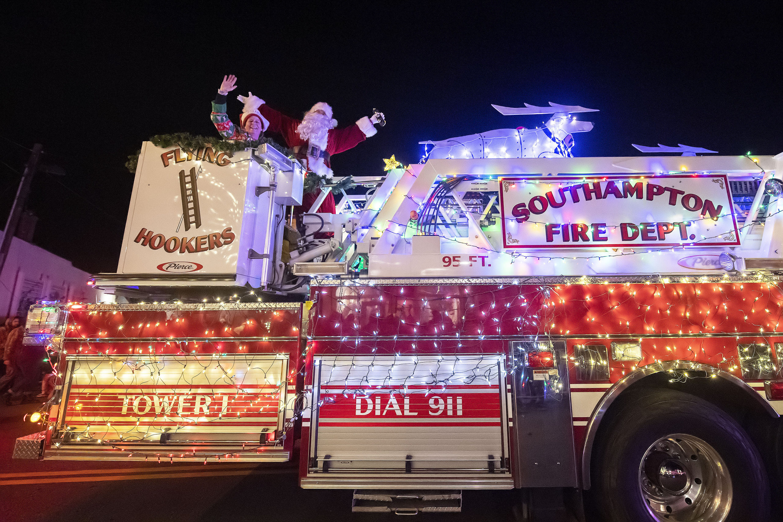 Santa Claus waves to the crowd from atop a Southampton FD ladder truck during the 2021 Parade of Lights along Jobs Lane on Saturday night.   MICHAEL HELLER