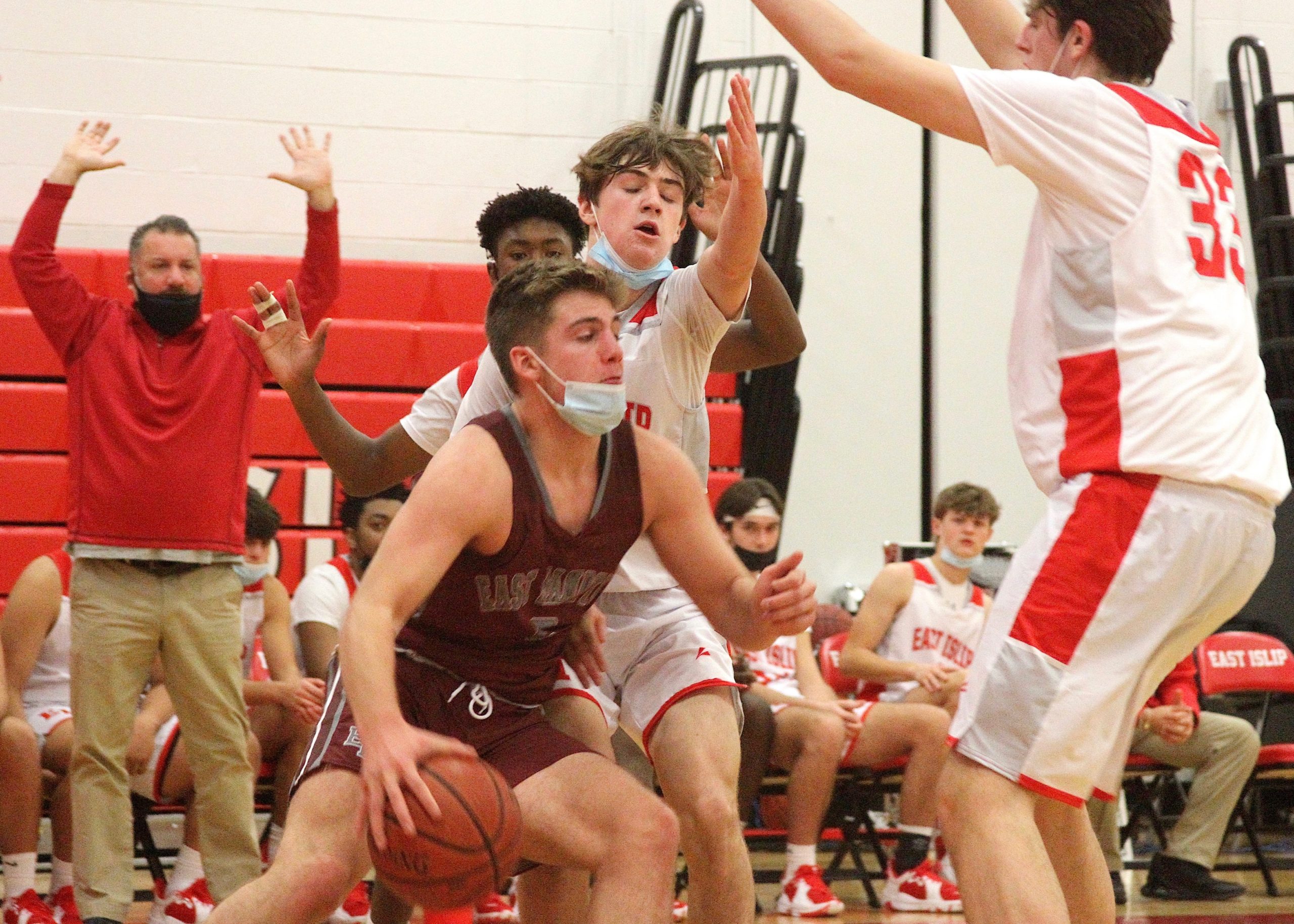Junior guard Jack Dickinson bulls his way around blocks by East Islip's Jared Kelly (far back left), Gavin Veltman (4) and Brandon Kearney (33). DESIRÉE KEEGAN
