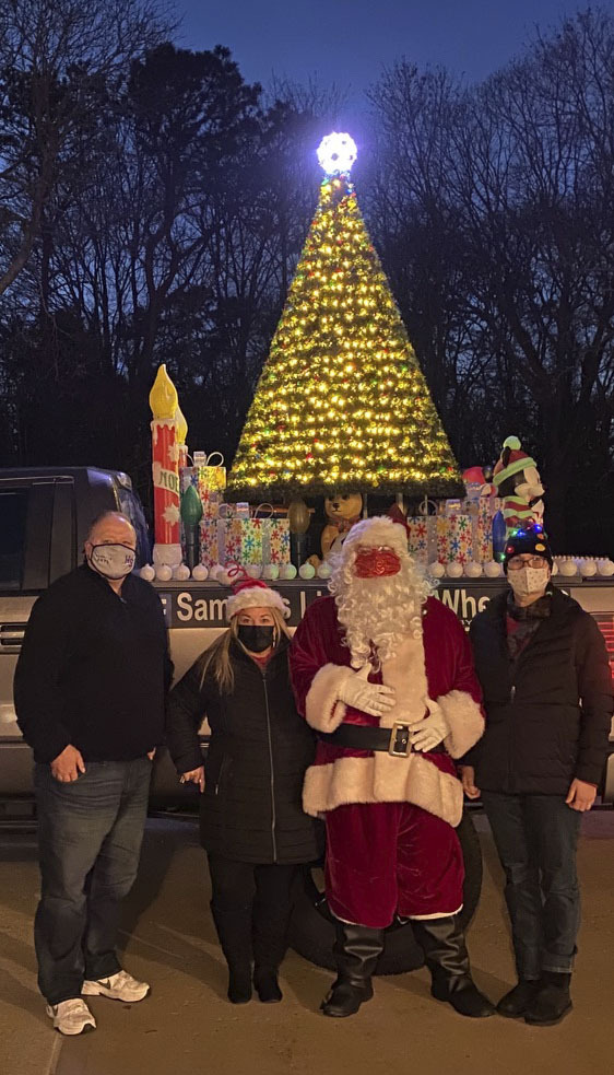 Councilman Rick Martel, The Friends of the Hampton Bays Library board members Emily Cullings and Christine Taylor and Santa in front of Sammy's Lights on Wheels at the Friends of the Hampton Bays library's 2nd Magical sleigh ride through Hampton Bays on Friday night.