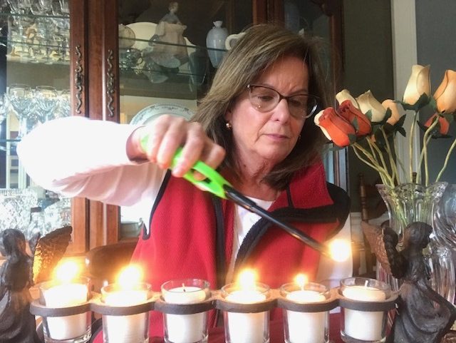 Jean Behrens, the adult bereavement coordinator at East End Hospice, lights candles in memory of her loved ones during the holidays.