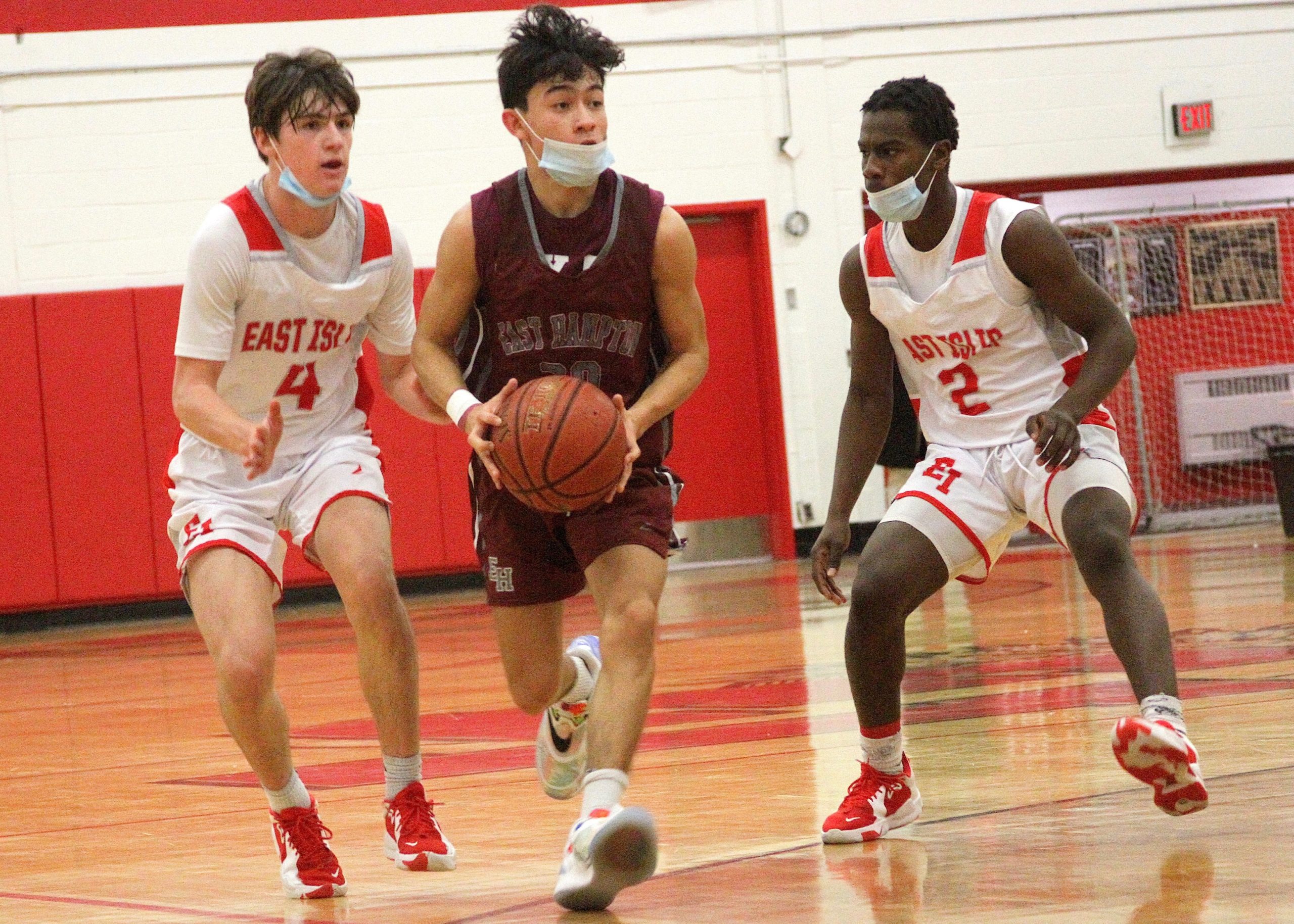 Senior guard Hector Montanaldo carries the ball between East Islip's Gavin Veltman and Peterson Lowman. DESIRÉE KEEGAN