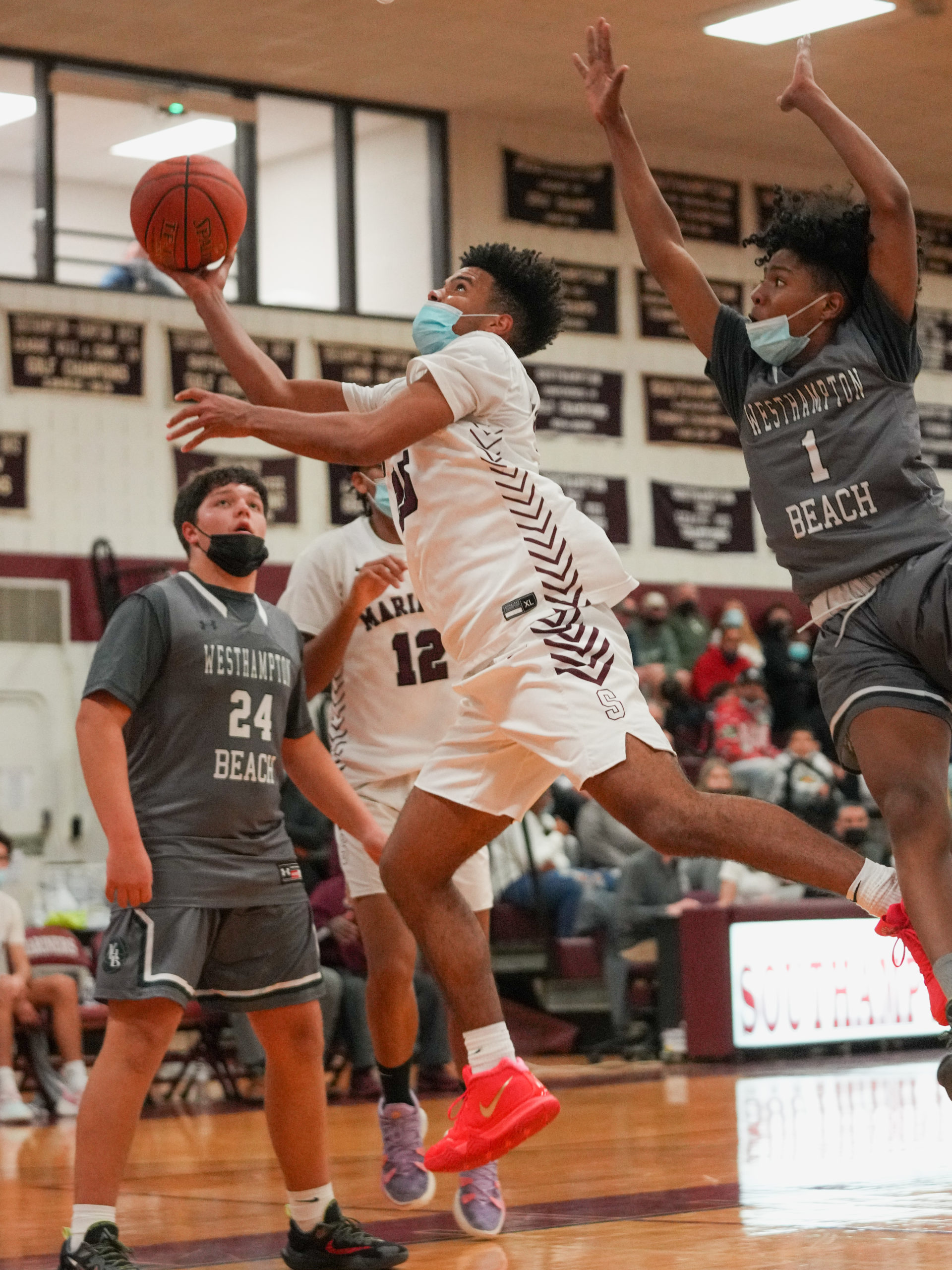 Mariner LeBron Napier weaves his away around Westhampton Beach defenders for two of his 30 points in the game.