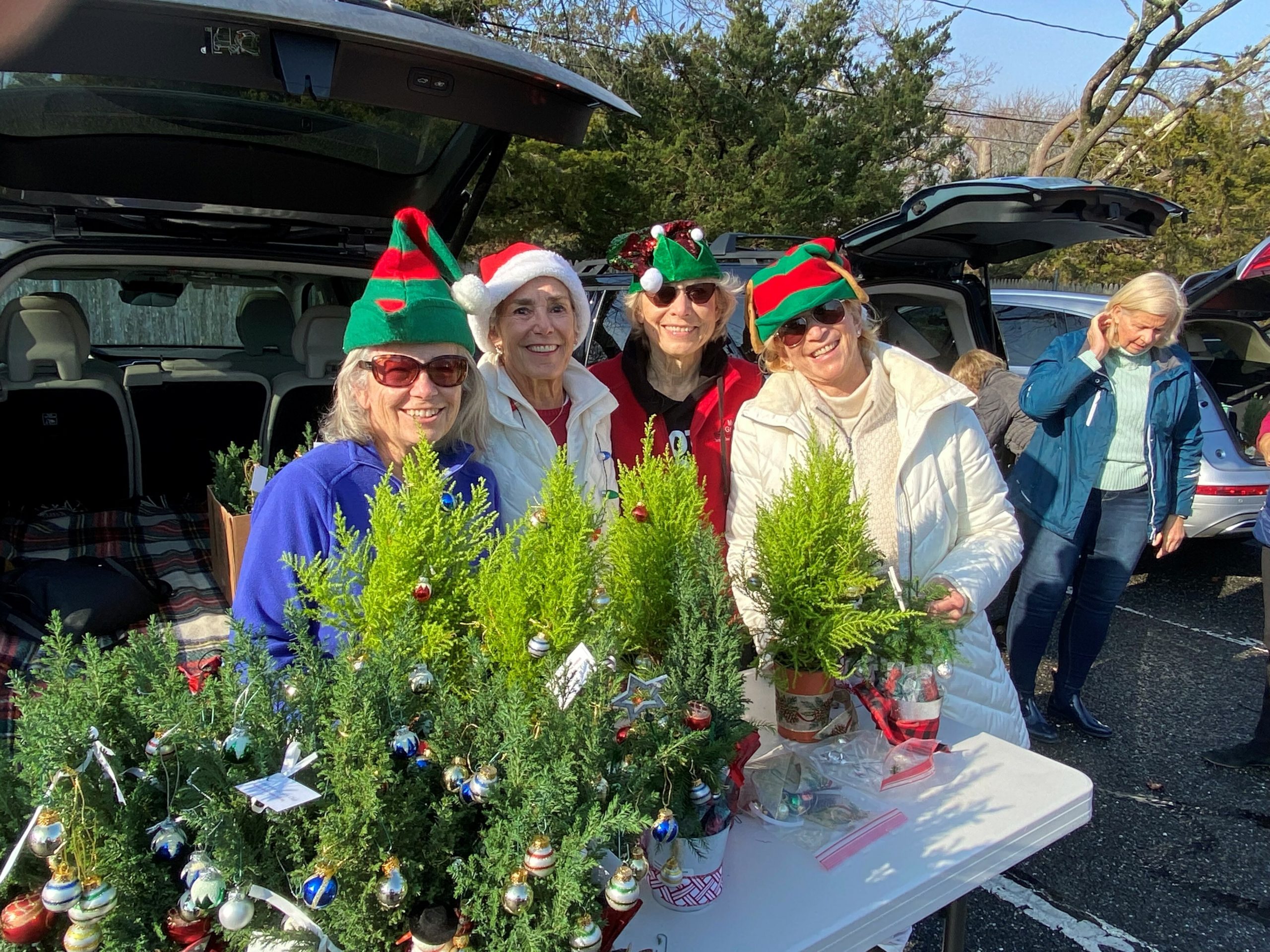 Unable to hold its the annual topiary decorating
workshop for East End Hospice indoors at the Quogue Firehouse due to COVID guidelines, determined Westhampton Garden Club members created an alternative. Topiary Chair Barbara Sartorius and club President Mellissa
Morgan Nelson, along with other members, organized a tailgate workshop outdoors in the firehouse parking lot.
Masked members parked their cars in two rows with tailgates up to serve as “workshop” spaces to bedeck the topiaries with ribbons and holiday ornaments. The finished topiaries were distributed to hospice patients throughout the East End and at the Kanas Center for Hospice Care in Westhampton.
“Through the topiary workshop and our year-round planting program at the
Kanas Center, we are privileged to support the mission of East End Hospice,”
noted WGC president Nelson.