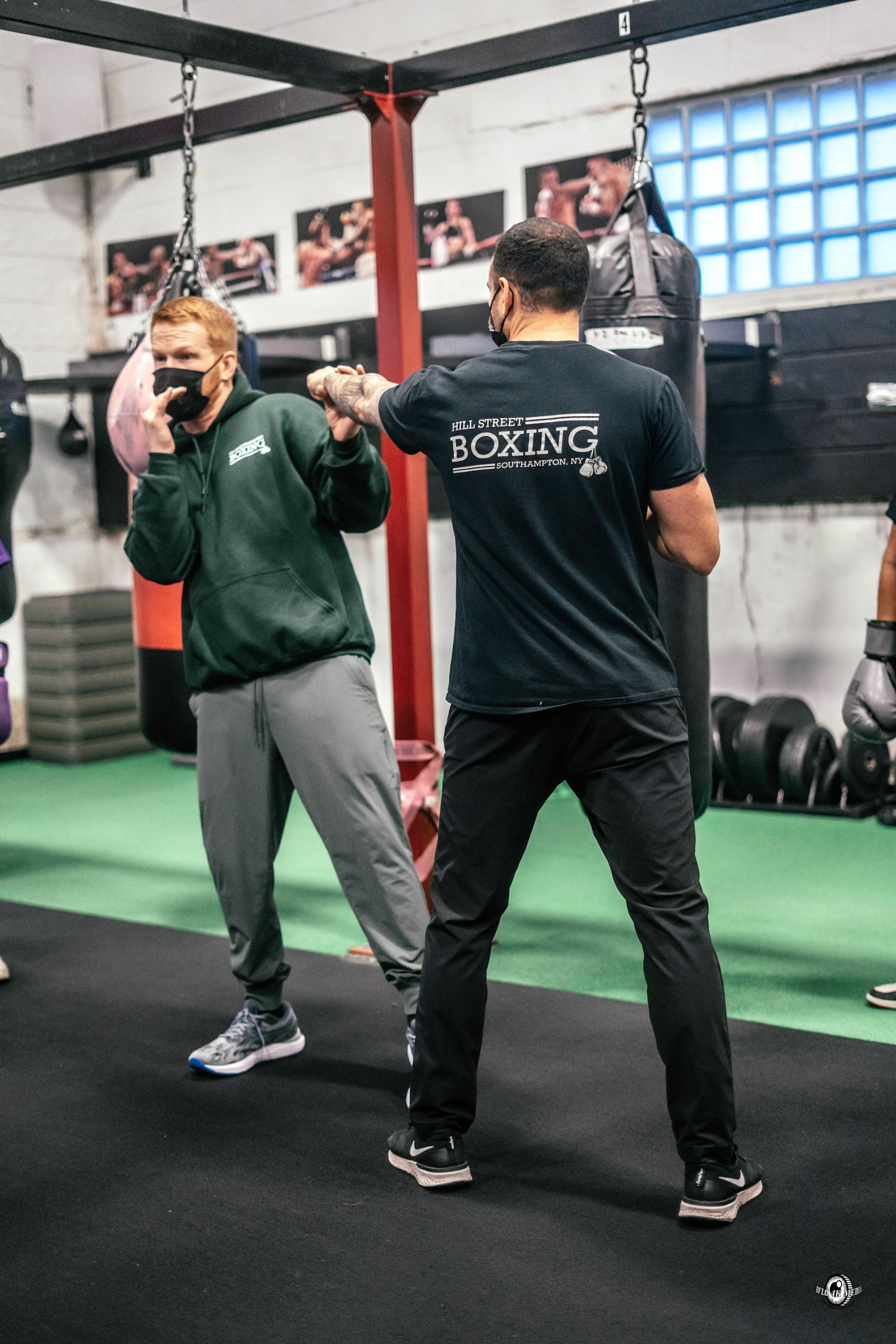 Hill Street Boxing manager and trainer Avery Crocker and Hampton Bays social worker Chris DeRosa demonstrate a block.