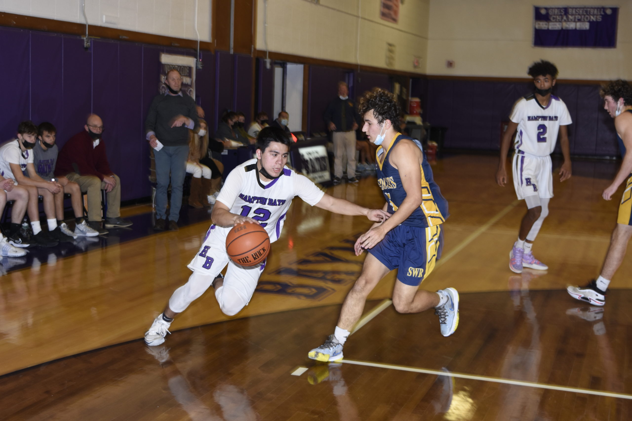 Hampton Bays senior Chris Sanchez drives on a Shoreham-Wading River player.