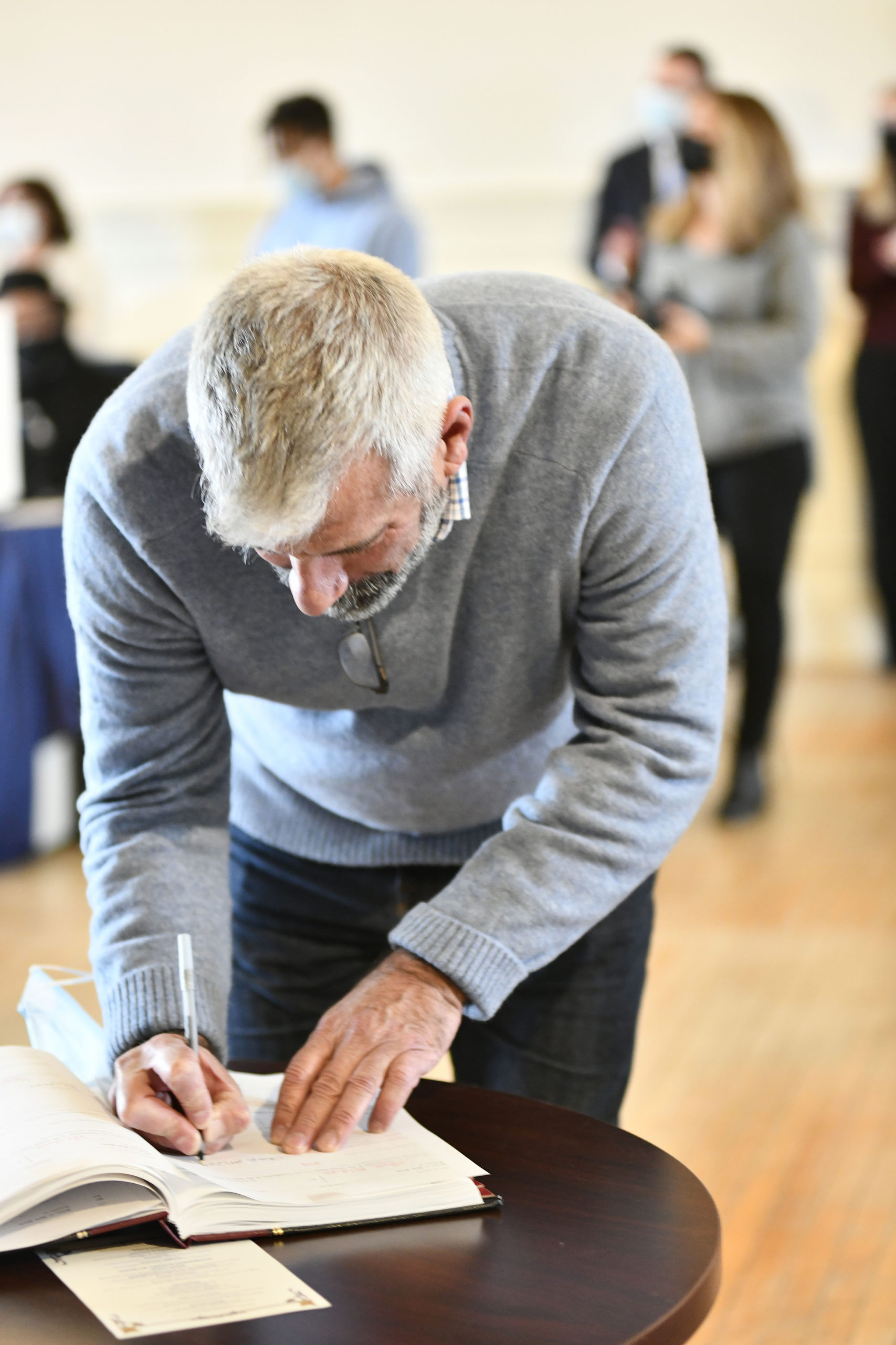 Charles McArdle signs the book after being sworn in on Wednesday.