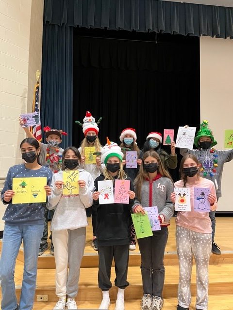 To help bring holiday cheer to troops serving overseas, members of the Hampton Bays Middle School Tri-M Junior Music Honor Society recently created holiday cards. The students, under the direction of adviser Carolanne Mazur, wrote thoughtful notes and designed colorful card covers.