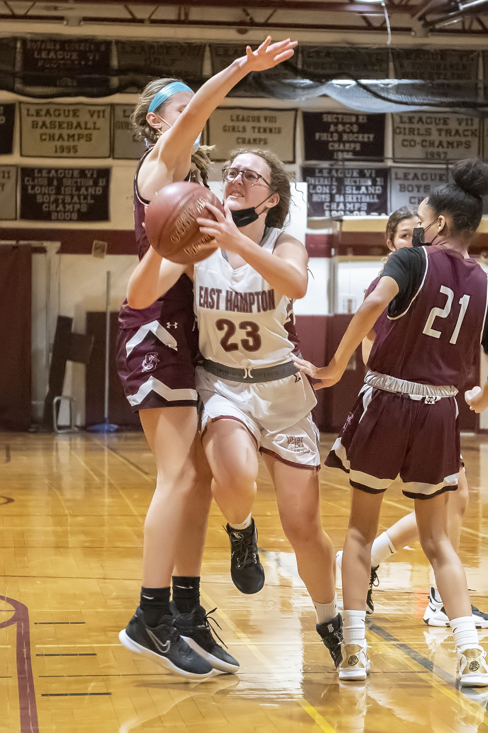 East Hampton's Chloe Swickard tries to make her way by Mariners Juliette Archer and Daelyn Palmore.